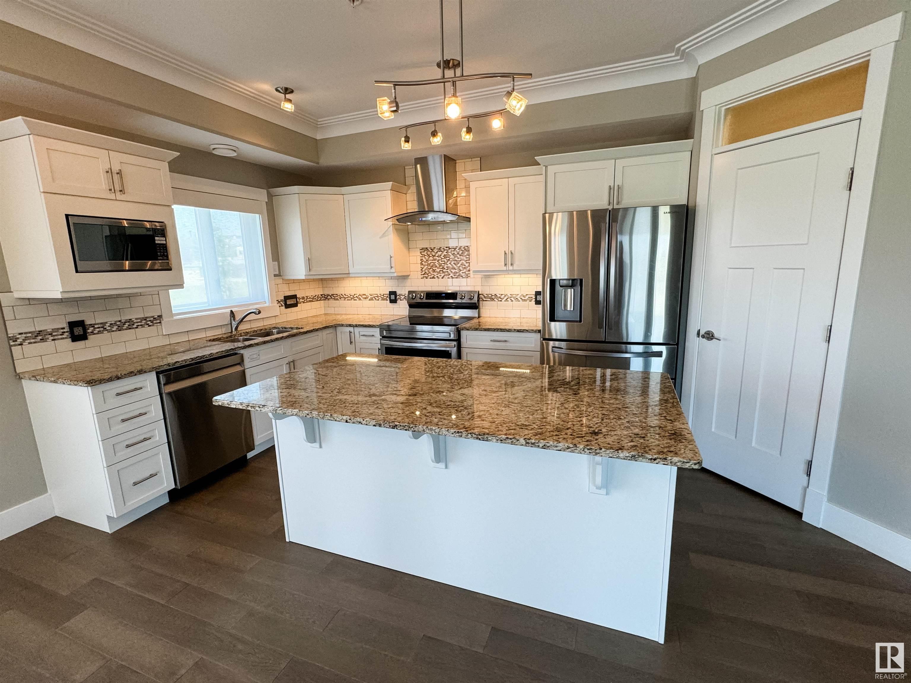 Amazing new price on this Stunning Luxury Condo! Experience security & style in this gated property with underground parking & secure storage. The beautifully designed building features an events room with a kitchenette, dining area, living room, and patio?perfect for entertaining larger groups. This 3rd-floor unit offers over 1,500 sq ft of living space complete with high end details like 9ft tray ceilings, transom windows & motorized blinds throughout. You'll find a chef?s kitchen with granite countertops, soft-close cabinetry, and a large walk-in pantry. The open living area has a n/g fireplace and hardwood flooring with 1 of 4 included TVs, that transitions to a large outdoor patio with views of IvanTo Park. The primary suite features a large walk-in closet, ensuite with double shower head/body sprays & sinks and a private deck. Two more bedrooms, a 4-piece bath, and in-suite laundry complete this beautiful home!