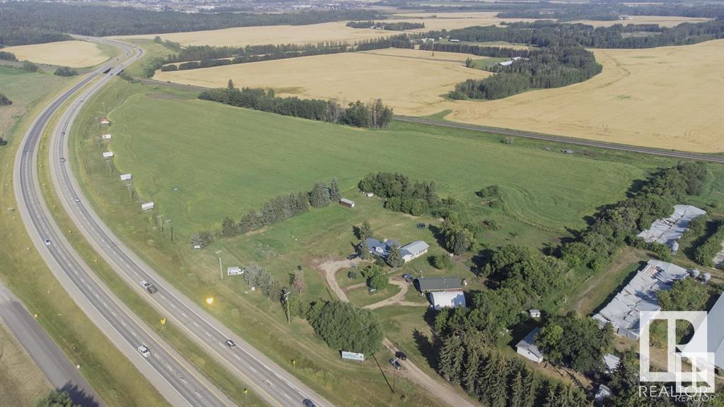 This prime 27+ acre property offers endless potential and is currently zoned as Agricultural General District but has been annexed into the Acheson Area Structure Plan. Enjoy the convenience of municipal water on this expansive property, featuring two dwellings and a quonset, providing ample space for your next venture. The main house boasts 1800+ sq ft above grade, with 5 bedrooms, 2.5 bathrooms, and a double attached garage with a convenient breezeway for added storage. The log house is a charming 1000+ sq ft abode with three bedrooms, one bathroom, and a cozy living room to kitchen concept. Situated along Highway 16A and just west of the popular Acheson Industrial area, this property is in a prime location. It provides current revenue streams with opportunity for more, making it an excellent investment opportunity. With plenty of room for your imagination, this unique opportunity could be yours. Don?t miss out on the chance to own this versatile and strategically located property!