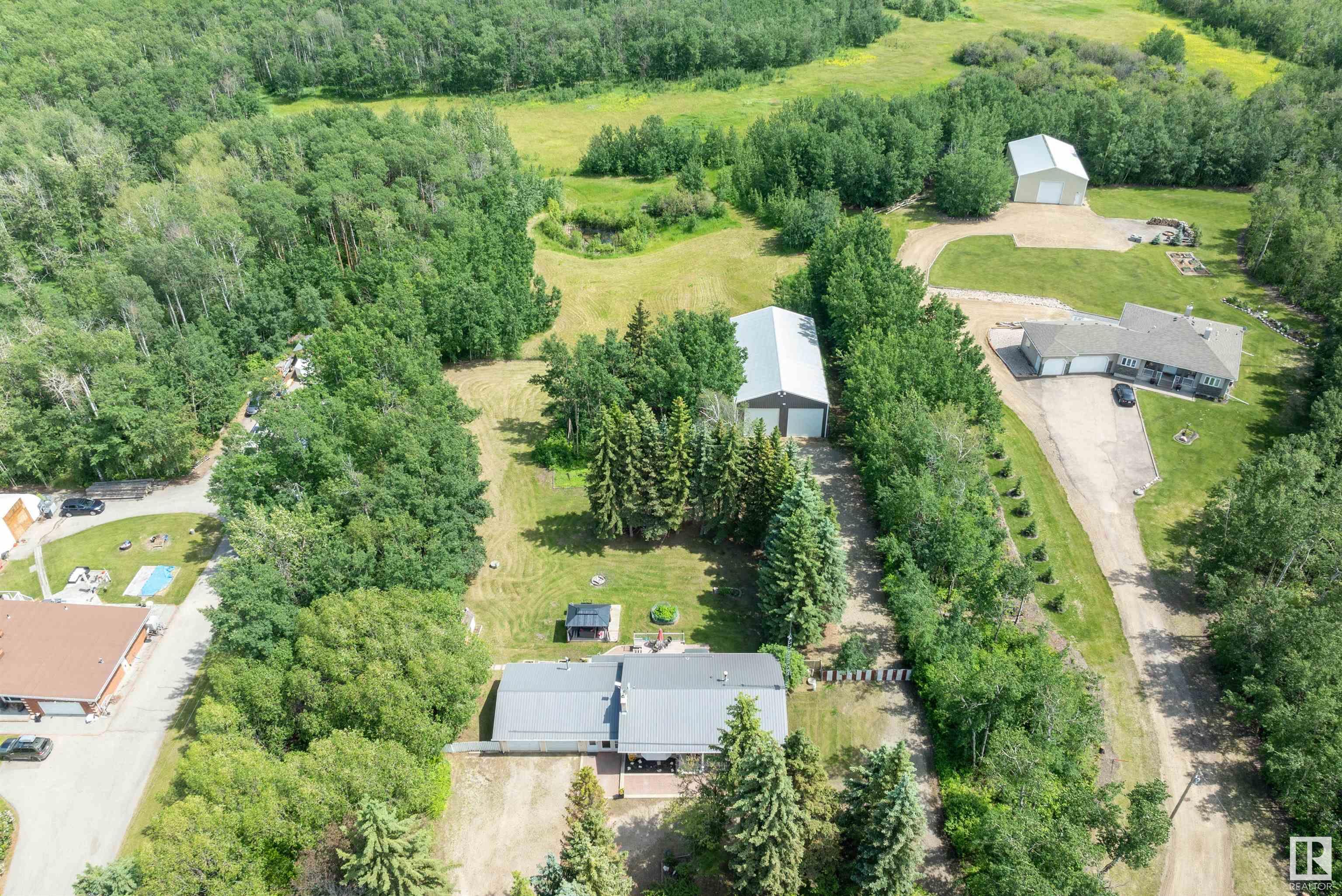 Super UPGRADED & UPDATED 1135 sq. ft. BUNGALOW on a 3.11 FENCED,TREED & ROLLING ACRES with a DOUBLE GARAGE plus a 70' x 38' SHOP with CONCRETE & POWER, MINUTES TO BEAUMONT/LEDUC. MODERN FARMHOUSE describes this COUNTRY HOME which offers a CENTRAL FOYER, a generous LIVING ROOM features newer LUXURY VINYL PLANK & large picture window. The SPACIOUS KITCHEN has an abundance of RICH WHITE CABINETS with BLACK ACCENTS, a CENTRAL ISLAND with a newer GAS COOKTOP, PANTRY, KNOTTY PLANK FLOORING, great DINING SPACE & access to the COMPOSITE DECK & HOT TUB & YARD. The main bath combines an 4 PC. BATH & plenty of room for the LAUNDRY! Two large bedrooms complete the main floor. Down the CENTRAL STAIRCASE to the FINISHED BASEMENT offering a lovely family room with HI EFFICIENCY FIREPLACE plus a 2nd KITCHEN with fridge and stove. A 3 piece bath with shower & upgraded dual flush toilet,plus 2 generous sized bedrooms PLUS DIRECT ACCESS UP TO THE BREEZEWAY. UPGRADED FURNACE, HWT, METAL ROOFS, PVC WINDOWS & SEPTIC, PLUMBING.