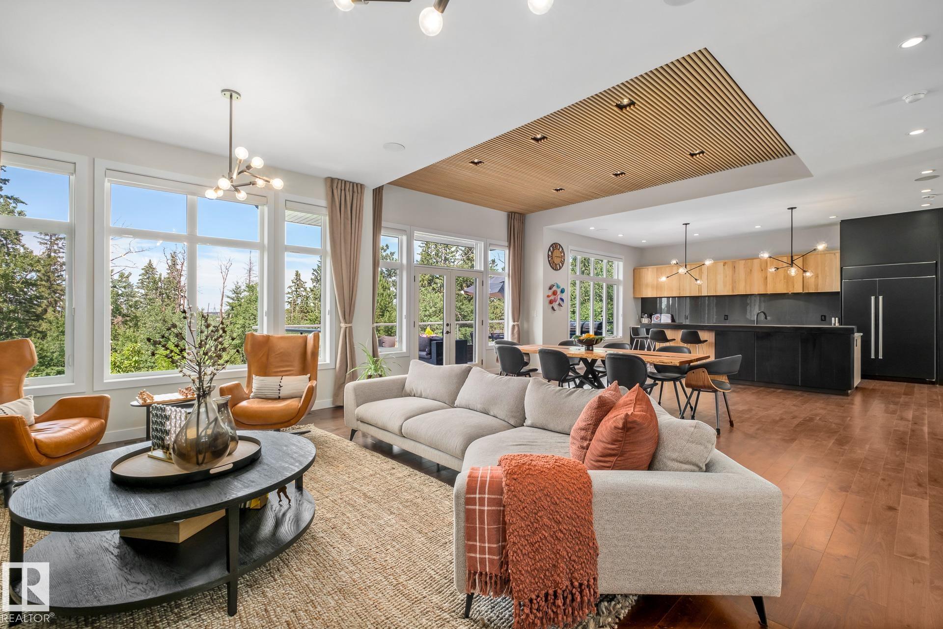 Stunning former Ace Lange Showhome offering over 5,400 sq ft of refined living space, backing onto the Whitemud Ravine & steps to Jagare Ridge Golf Course. This fully finished walkout features 4 beds, office, den, 4.5 baths, and a heated triple garage (one bay currently an office/storage). Chef inspired kitchen with Sub-Zero fridge, Wolf double gas stove, walk-in pantry, and wet bar with Sub-Zero wine cooler. 10' ceilings on main floor, massive windows, main floor deck, and upper balcony offer incredible ravine views. Luxurious primary suite with spa-like ensuite and walk-through closet. Upstairs bonus room, two bedrooms with private ensuites. Basement includes a bedroom, den, reading nook and huge rec space with a wet bar that opens to a beautifully landscaped yard ($60K+ in landscaping). Loaded with upgrades, including radon prevention system, Kinetico water softener, radiant floor heat in garage, primary ensuite & basement. A perfect blend of luxury, comfort, and nature in sought-after Jagare Ridge.