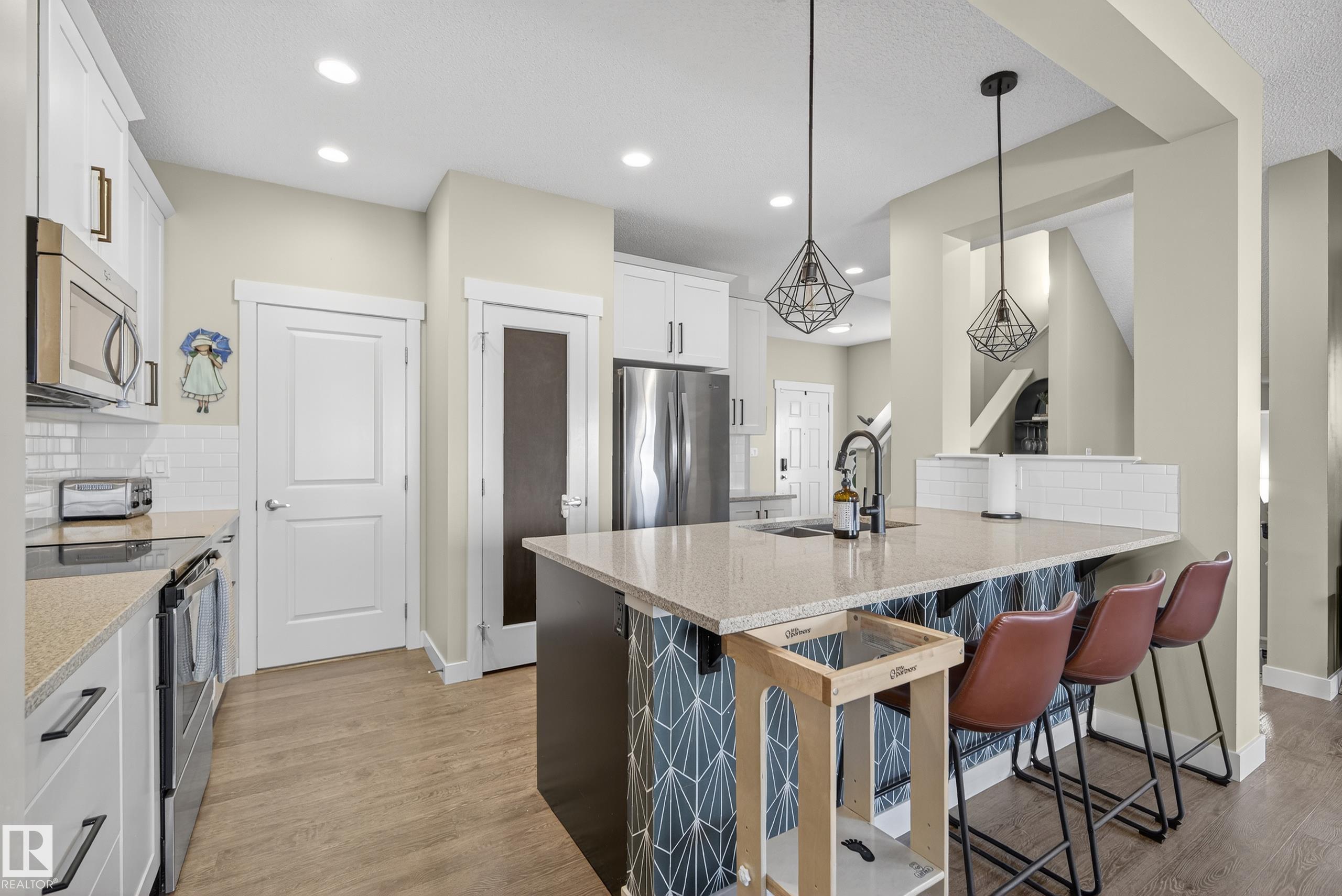 This fully finished two-storey home offers nearly 3000sq ft of trendy living space in a prime location, steps from the pond, scenic trails, picnic areas, and a small park. The main floor features an open-concept design with a spacious kitchen, living room, and dining area. The kitchen boasts abundant cabinetry, quartz countertops, and stainless steel appliances, with a convenient walk-through mudroom connecting directly to the 23x21 oversized, double attached, insulated garage. The living room includes a gas fireplace, while the dining area opens onto a deck overlooking the large, fully fenced yard and tranquil pond views. Upstairs, the colossal primary suite is a true retreat, featuring double walk-in his-and-hers closets and a luxurious 4-piece ensuite. Two additional bedrooms, 4-piece bath, bonus room with large window,  upper-level laundry room adds comfort and convenience for the whole family. Basement level is fully finished and has 4th bedroom with W/I closet, 4 pce bath and family/recreation room.