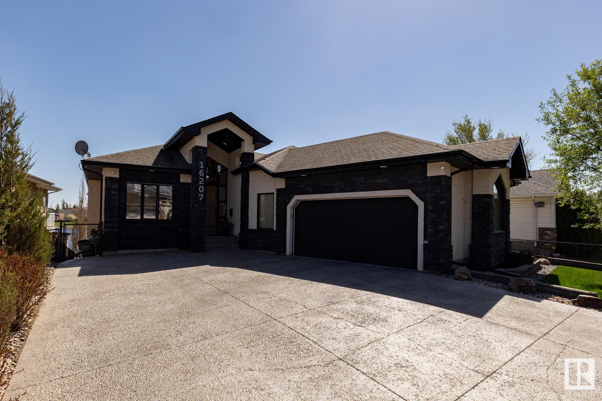 Original Owners of this stunning, elegant and well appointed hillside bungalow literally backing onto pristine Belle Rive Lake, just open the gate and get those feet wet. This beauty sports 3 main level bedrooms and 2 bathrooms including 5 piece ensuite, an open concept main living area with brick fireplace, vaulted ceiling with recessed lighting, spacious kitchen, formal dining room and sophisticated library. Exit the dining space onto a perched deck overlooking the most beautiful lakeside views. The basement offers a spacious recreation and games area with wet bar, wood burning stove, 2 extra bedrooms and a 4 piece bathroom, den for an office or gym & large storage space with cold room. Exit onto a private patio overlooking a gorgeous professionally landscaped backyard. Hardwood flooring, granite counters, fireplace and exterior brick work, epoxy garage floor, lights, cabinetry, fixtures, irrigation system, AC, garage heater, custom landscaping lights and much more. This gem will NOT disappoint.