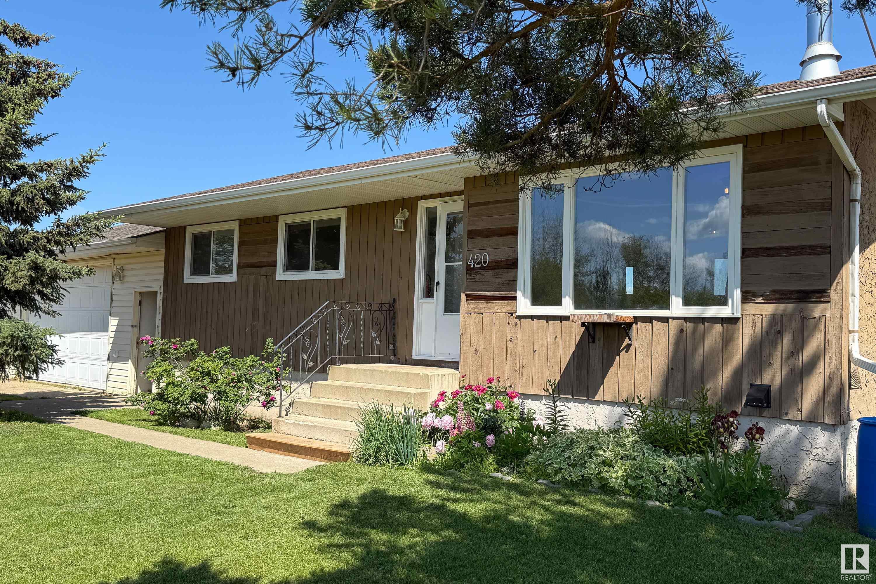 Looking to escape the city without going off the grid? This 4-bed, 3 bath home is your perfect balance of peace and proximity; just 1 hour from Edmonton and 30 minutes to Westlock! The main floor features an open-concept kitchen with quartz countertops, white cabinetry, and stainless steel appliances. A beautiful fireplace is located in the living room, and the dining area overlooks the deck, perfect for the BBQ. Finishing off the main floor are 3 bedrooms, including the primary with a 2-piece ensuite. The basement is mostly finished and boasts a huge family room with a wood-burning fireplace, a massive 4th bedroom with a walk-in closet and an ensuite, plus a laundry/mechanical room. Air conditioning only two yrs old! The garage is truly oversized—ideal for hobbies or a workshop. Situated on a corner lot facing open fields, you'll enjoy unbeatable sunsets, stars, and even the northern lights. A few finishing touches, like flooring and baseboards, will turn this home into your country dream retreat!