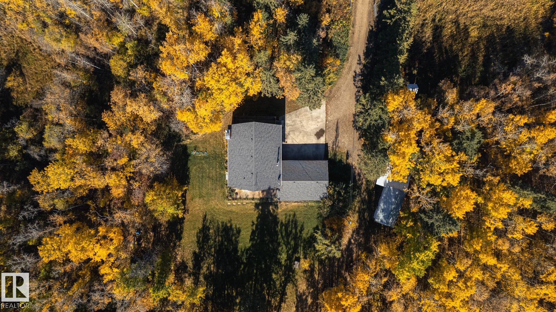 This unique & remarkably spacious 2950 SqFt two storey sits on 4.82 acres of land (128m x 152m) just east of Rolly View on Hwy 623. Main level features mud room, laundry room (which could be converted back to bedroom), large kitchen, living room with patio doors to deck, family room with fireplace, dinning area & 3-piece bathroom. Upper level has a family bathroom, four bedrooms including a primary with a walk-in closet, sitting area, 3-piece ensuite & access to a large deck that overlooks the expansive property.  Basement has family room with heat stove, bedroom, bathroom, cold room and storage. Home has a massive double attached garage. Property has an upgraded sewer system, wood shed, lean-to & chicken barn. Note that home is comfortably liveable but could use upgrades, repairs and cosmetics. Sold as is.