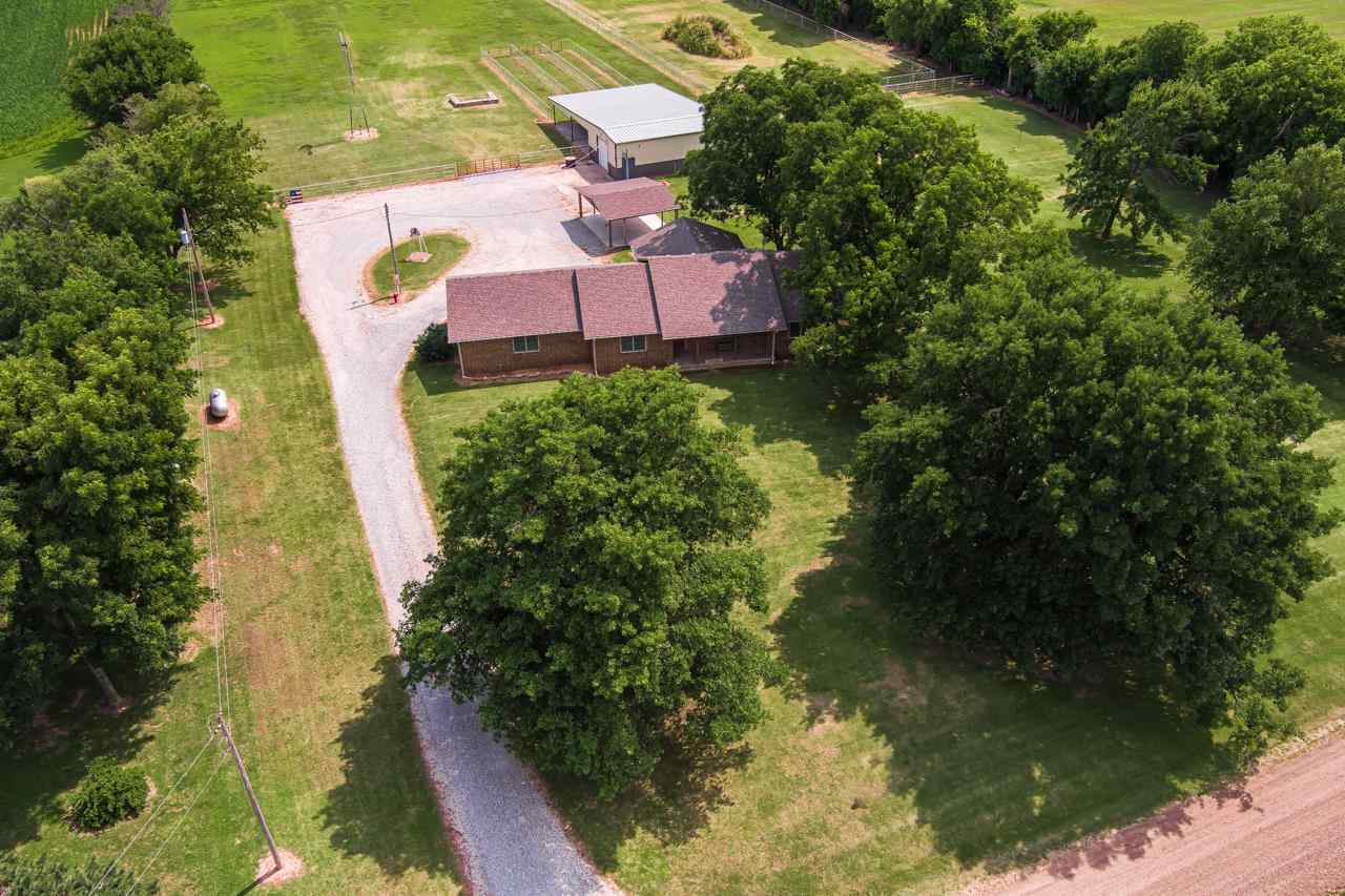 Equestrian dream is WAITING FOR YOU! This custom built one owner all brick ranch is set on 9.7 acres and is perfectly suited, fenced and ready for you to move in and bring your horses or other livestock! The house is equally as pleasing as it is very well kept and you will feel the pride in ownership from the moment you arrive! The large living room is very spacious with plenty of space for your sectional or large television. Off the living space is an updated kitchen sure to make the cook in your family happy! Tastefully updated with granite, nice sized island, two ovens, lots of counter top space and tons of cabinets! The master suite offers private master bathroom and walk in closet and a split master floor plan! The two additional bedrooms are both nice sized with good closet space! Additionally, on the main you have a full hall bathroom, and mudroom with laundry and wash sink. In the basement you have a 4th bedroom, full bathroom, and partially finished rec room! With plenty of room for storage and a concrete storm cellar the basement has much to offer! As you head outside you will love the covered patio with composite decking and large carport! The detached shop is fully insulated and climate control with its own heat and air, it is the shop you have been wanting and it offers stalls and a lean to for your tractors and other equipment/toys! The land is great pasture and it is already fenced and ready for you! If this sounds like the home you have been searching for call listing agent today and schedule a showing!