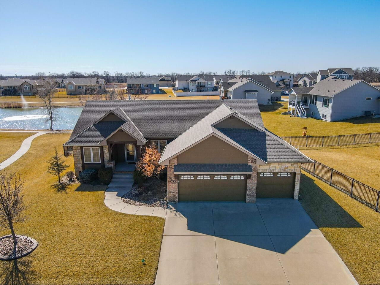 Welcome to your new home!  This semi-custom Miller Family Home in in the highly desirable Clear Creek Addition boasts ample pride of ownership!  This 3,005 sq ft home has fresh paint throughout the interior, stain-grade (and caulked) baseboard moulding on both levels, updated LED lighting throughout, new ceiling fans on the main level (2 w/remote controls), 10’ ceilings on main level, newer LVT flooring & architectural windows looking out onto a beautiful water-front view.    Kitchen features lighted, large walk-in pantry & new (2021) GE appliances (GE dishwasher was installed in February 2023).  Granite countertops & work island with eating bar, and bkfst nook with entry onto the deck.  Separate laundry room also features new (2021) GE front-load washer & dryer set with pedestals, a granite counter folding area & upper and lower cabinets.  Open concept, split bedroom design with a spacious master suite with vaulted ceiling that accommodates a king-sized bed & accompanying furniture.  Master bath features twin granite vanity sinks with new brushed nickel lavatory faucets (in all baths & lower level bar sink); jetted tub for relaxation & shower stall with sliding glass doors.  Master also has private door that opens onto a cozy deck with composite decking.  Perfect for relaxing!  Two other bedrooms on main level share a full bath with delightful architectural window for natural light.  All bathrooms have new ADA-compliant, water-saving toilets.  Cavernous, finished basement features a large family room with two VO windows that look out onto the spacious backyard & view of the community lake.  A large finished wet bar with slate tile finish and room for a wine/refreshment fridge.  Large bedroom with adjoining full bath.  A convenient mechanical room features a whole-home humidifier (installed 2021), and a semi-finished room off the family room for storage, wine room or exercise room!  Formal living room on main level features gas fireplace & custom woodwork.  Adjoining dining room accommodates a large extended dining table for large gatherings.  Wrought-iron railing allows you to enjoy the water view from the comfort of your new home year-round!  Oversize lot features a private irrigation well that feeds a complete sprinkler system, decorative aluminum wrought iron-type fencing that allows views of the community lake, & mid-level WO that opens to a large patio for entertaining.  The garage doors are fully insulated.  Large, welcoming front entrance to your new home.  New insulated fiberglass skin front entry door with leaded glass insert and Larson ventilating storm door (w/locking feature).  Both doors installed Feb 2022.  Special taxes pay out this year.  Schedule a showing today!  This home won’t last long!