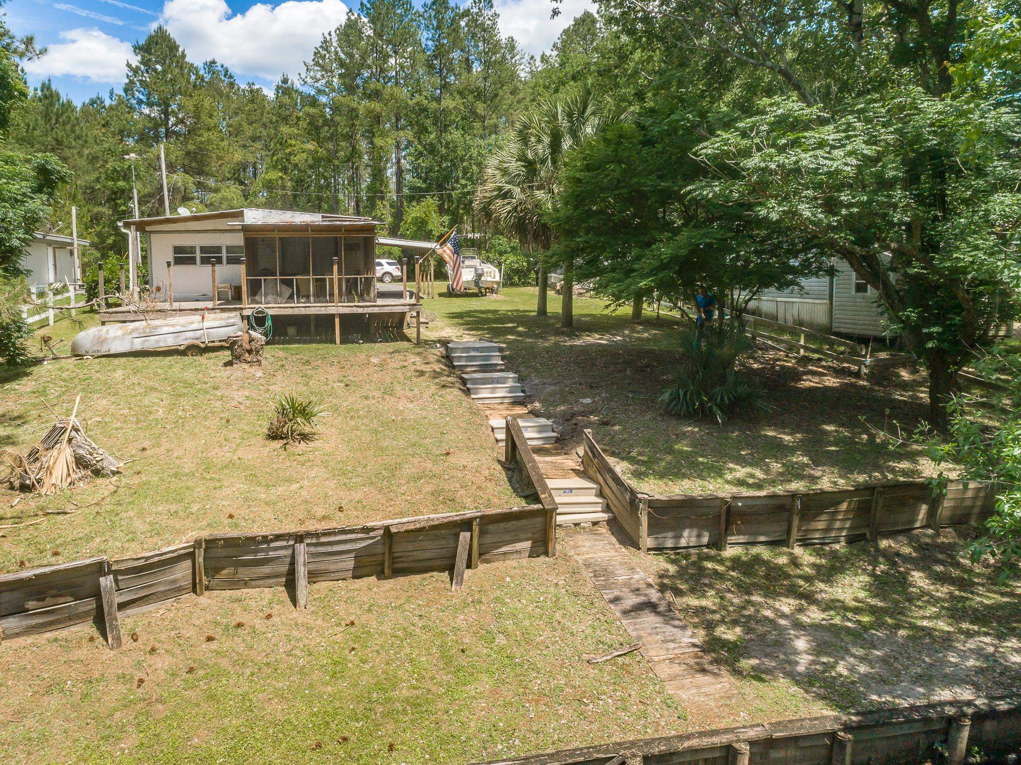 Not your ordinary Fish Camp!! This 1966 Renovated/Updated Mobile Home is Full of Charm. 3 bedrooms & 1 3/4 baths- plenty of room for family & guests.  With the Built-Over Roof, Built-On, Carport, Large front Porch, Open Deck, and Screened Porch overlooking the canal that leads to Bone Bluff Lake and the Ochlockonee River it's a water and boat lover's dream. There is outside storage for your water toys & fishing gear.  Moor your boat to Bulkhead Seawall for overnights & be ready for a day on the water. Only 2 minutes through the canal to Bone Bluff Lake which opens up into the Ochlockonee River. You are only 20 minutes to saltwater fishing and beaches. The home comes furnished and ready for occupancy. There is a mini-split Air Conditioning Unit and 2 window units for the built-on bedrooms to keep you comfy all summer long. Zoned RSU. All dimensions are approximate, please verify if important.