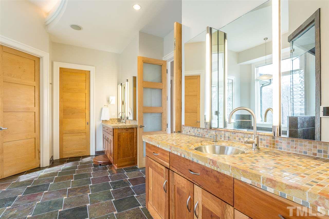 Two separate custom-built cherry vanities feature custom limestone mosaic countertops,stainless-steel sinks, pull-out drawers w/Hafele hardware and under-cabinet night lights. Contemporary Robern dual mirrored & lighted medicine cabinets grace each vanity
