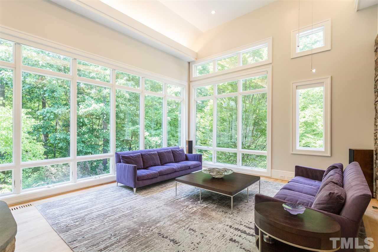 Upon entering the living room, you will be immediately captivated by panoramic views of pristine woodlands, including winter views of Lower Barton Creek. The expansive living room offers 2 walls of soaring windows that provide remarkable views.