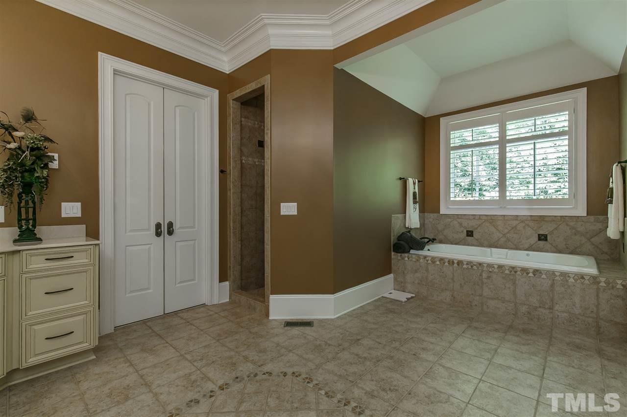 DEEP jet tub , trey ceiling, tile surround walk-in shower and doors to walk-in closet