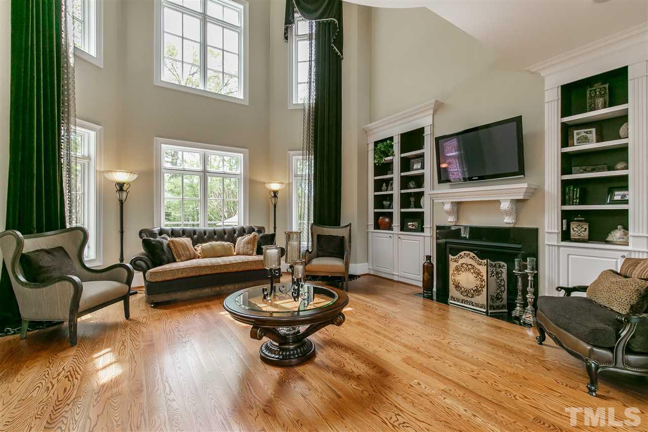 IMPRESSIVE 2 story living room with custom bookcases/cabinets and gas log fireplace