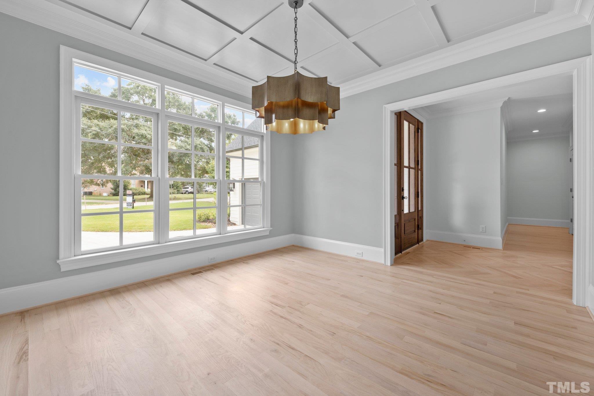 Spacious dining room with 9ft coffered ceiling and a one-of-a kind light fixture.
