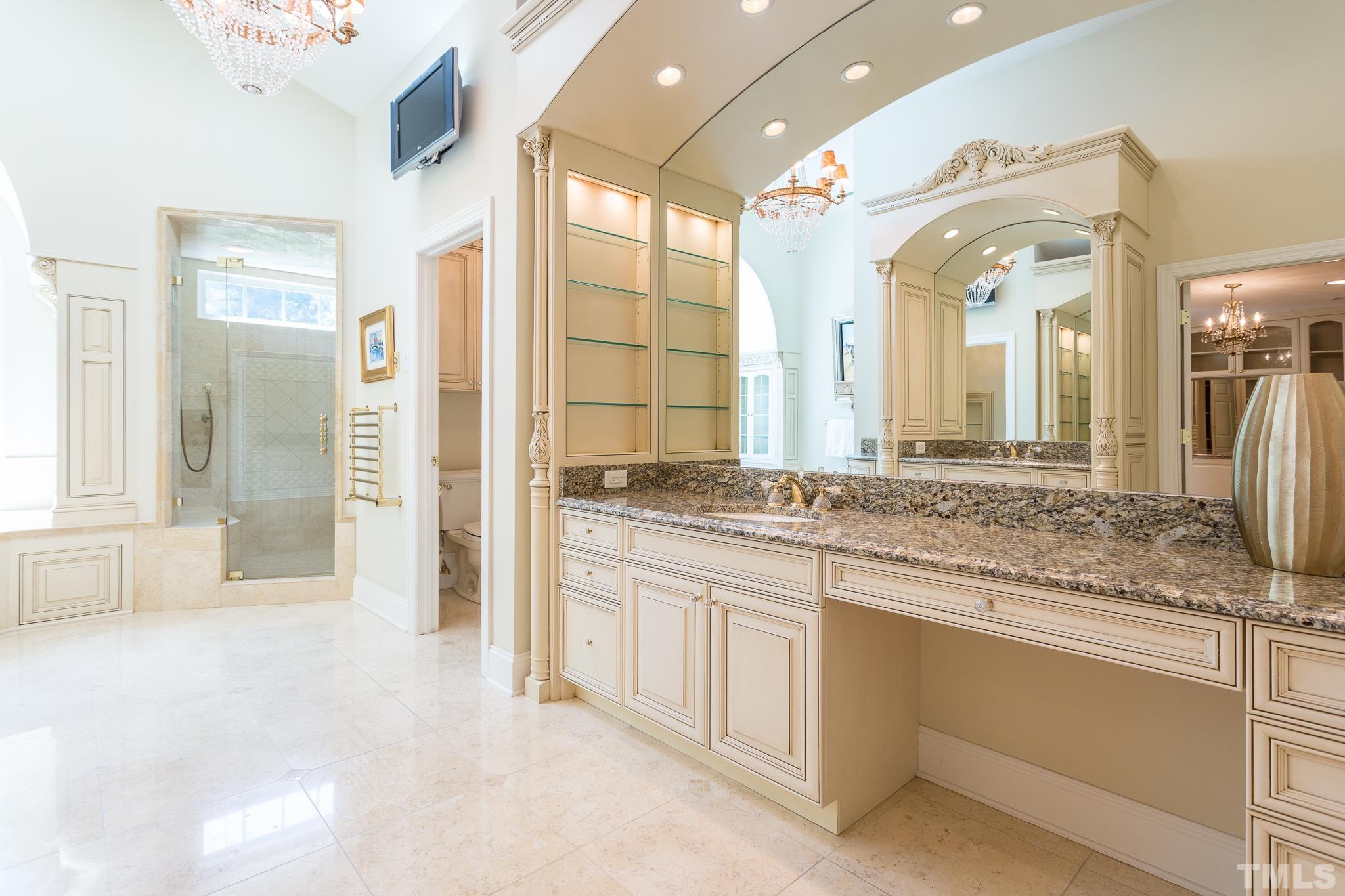 Sheer elegance abounds in the owner's suite bath as it is filled with luxurious features including programmable heated floors,heated towel rack, oversized walk-in shower w/multiple shower heads, including a rain shower head and seat ledge.