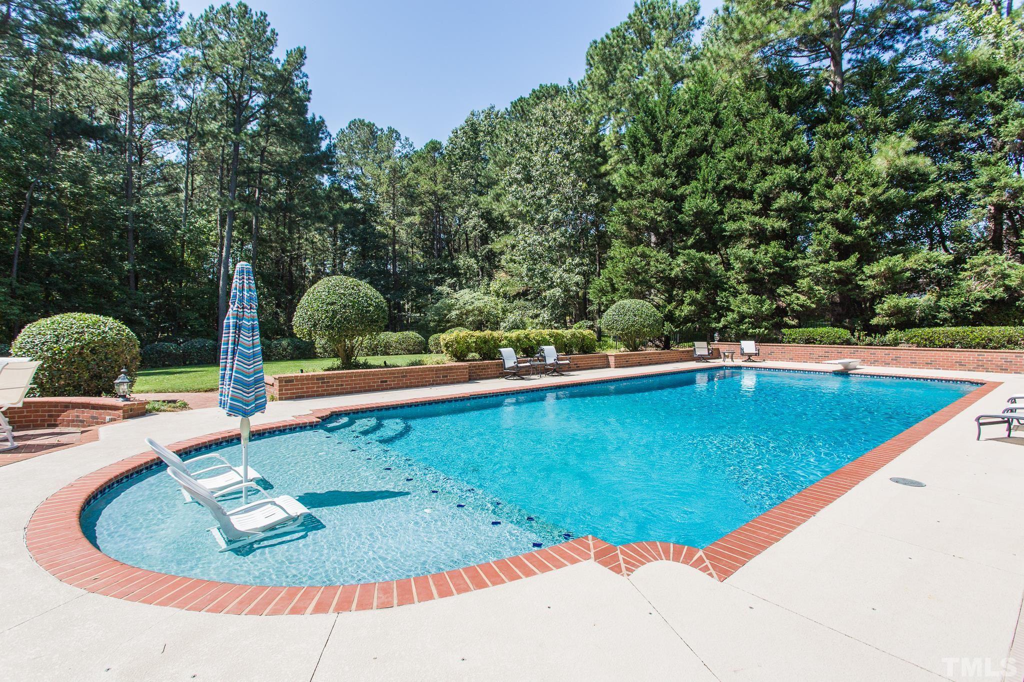 In-ground 60 ft x 22 ft, 9 foot deep,  saltwater pool installed in 2006 by Oasis Pools and offers a diving board and tanning shelf with water feature surrounded by large brick patio with Firepit