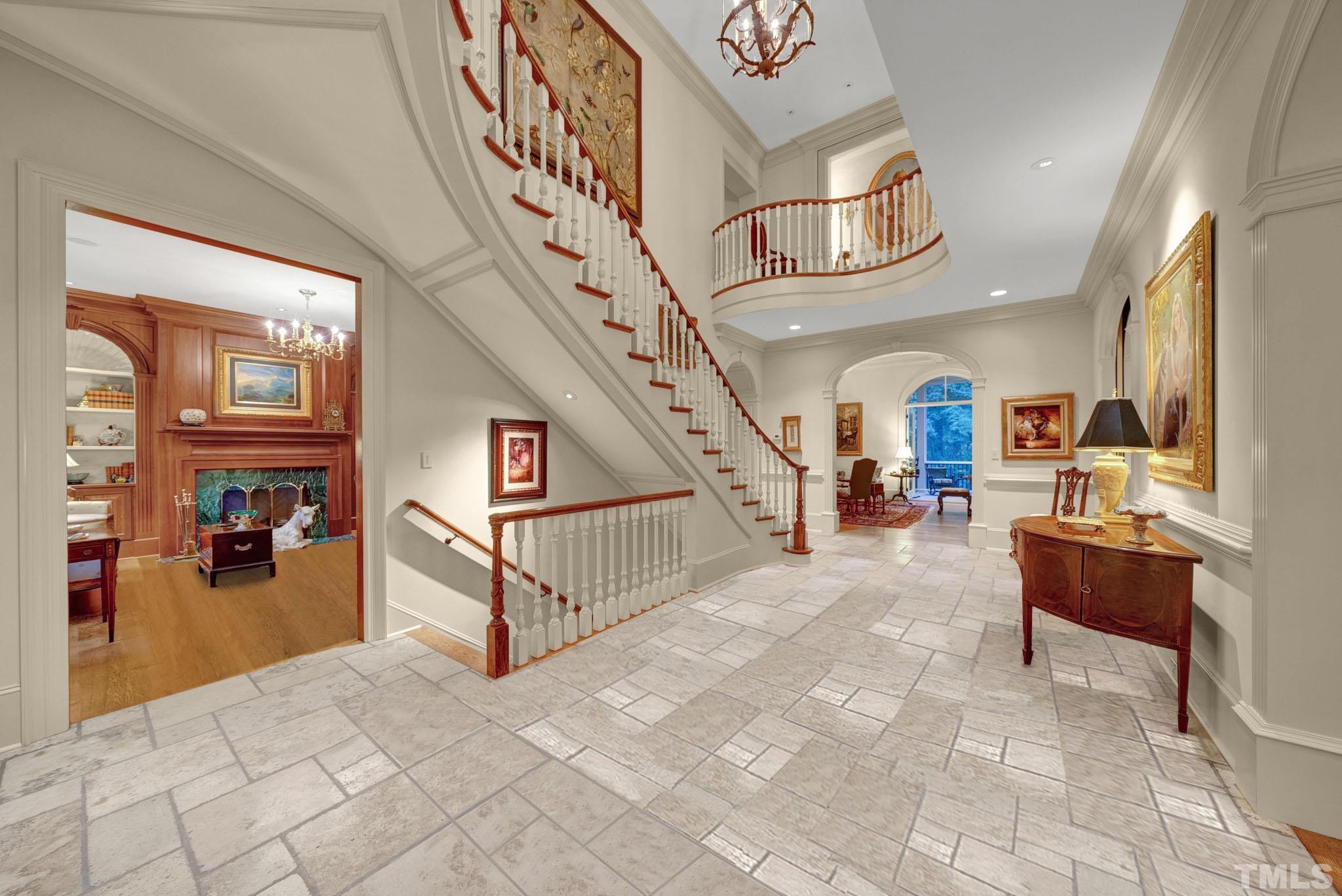 Gorgeous 2 story foyer w/traventine tile floors.  Custom carved balusters. This custom built home by John Rufty shows the quality of the house and attention to detail.