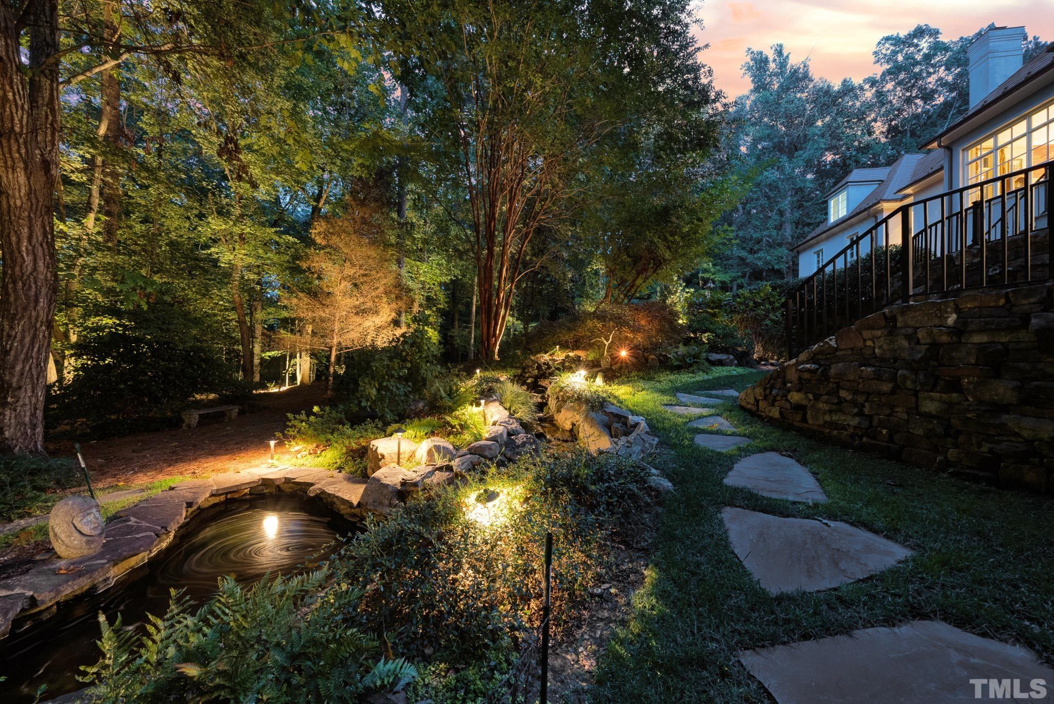 Gorgeous views of backyard at night with front and rear night scaping.  Relax on the screened in back porch listening to the rock waterfall.