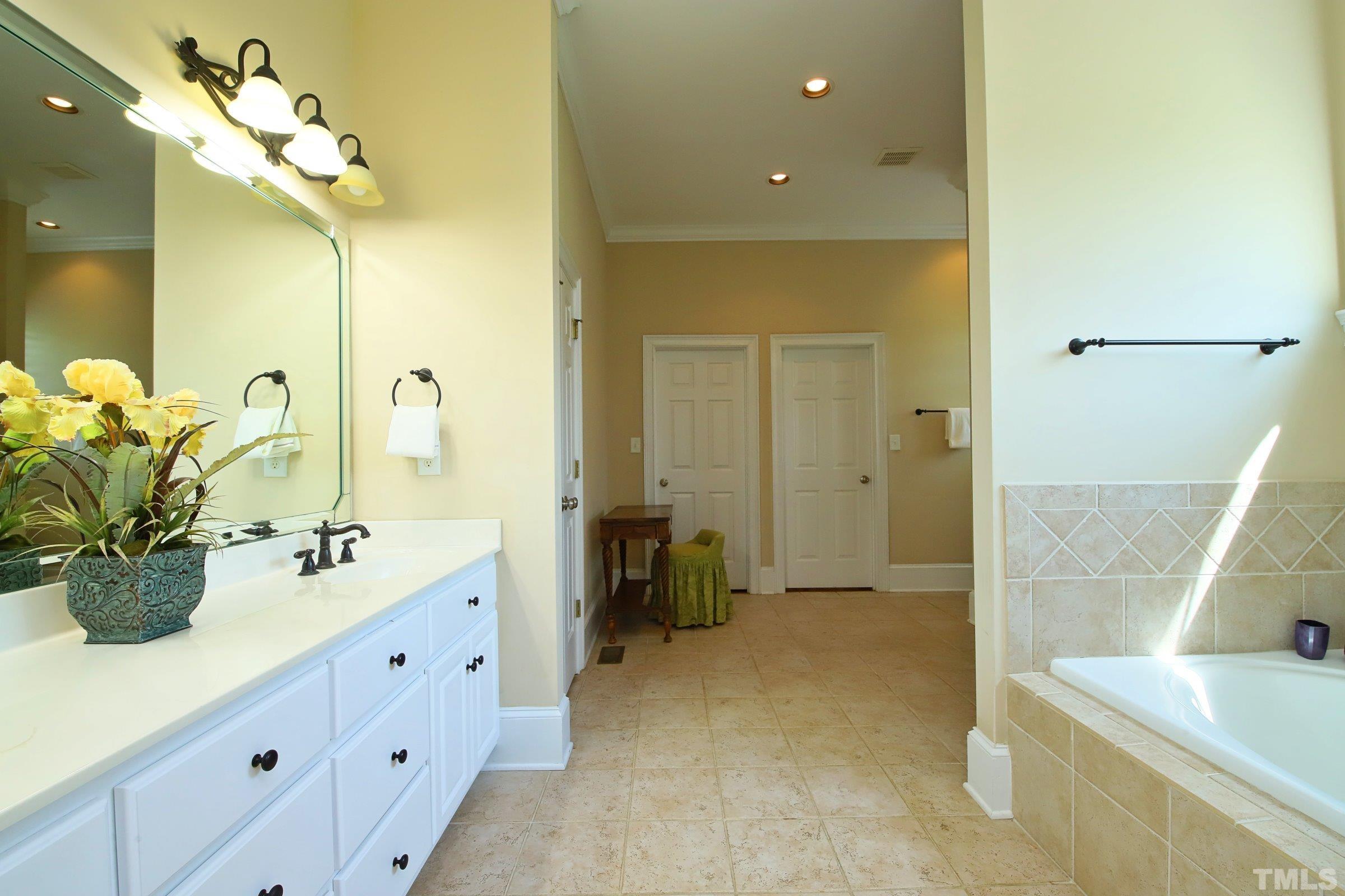 Spacious spa-like bath retreat features separate shower, double vanity, large soaking tub with custom tile surround and palladian window and two large walk-in closets plus roomy linen closet. Every inch luxury!