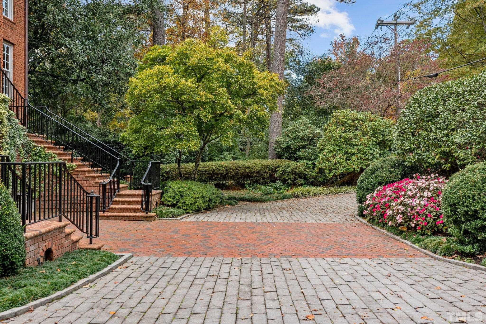 Gracious drive is nestled between double entry staircase and the lushly landscaped brick retaining wall.