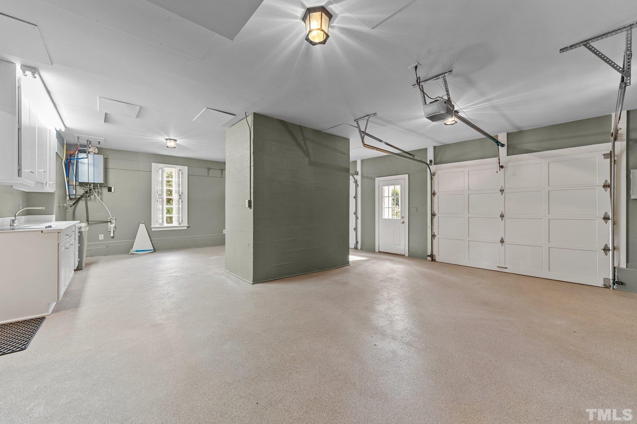 Extra large garage has double bays, apoxy floor, utility access closet and prep counter for caterers or family cooks. Note the 2018 tankless water heater!