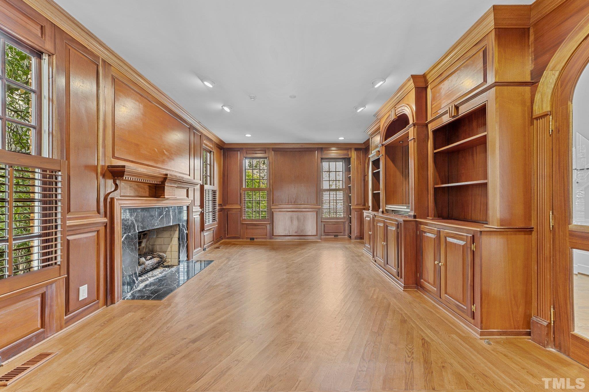 Handsome polished mahoghany walls, masonry marble faced fireplace and built in bookcases create a one of a kind retreat.