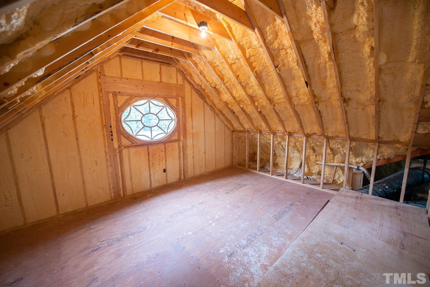 This attic is off from the bonus room. There are 7 attic spaces in the home. This is one that could be finished into expandable space in the future. You can also see the spray foam insulation in the walls. It keeps the attic cooler in the summer months.