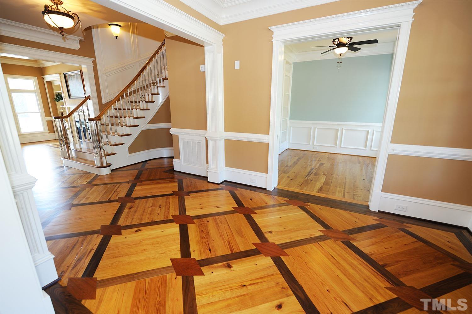 Caribbean Heart Pine hardwoods throughout foyer with custom design walnut and cherry accents. Headers above doorways are hand-painted and glazed in egg & dart pattern.