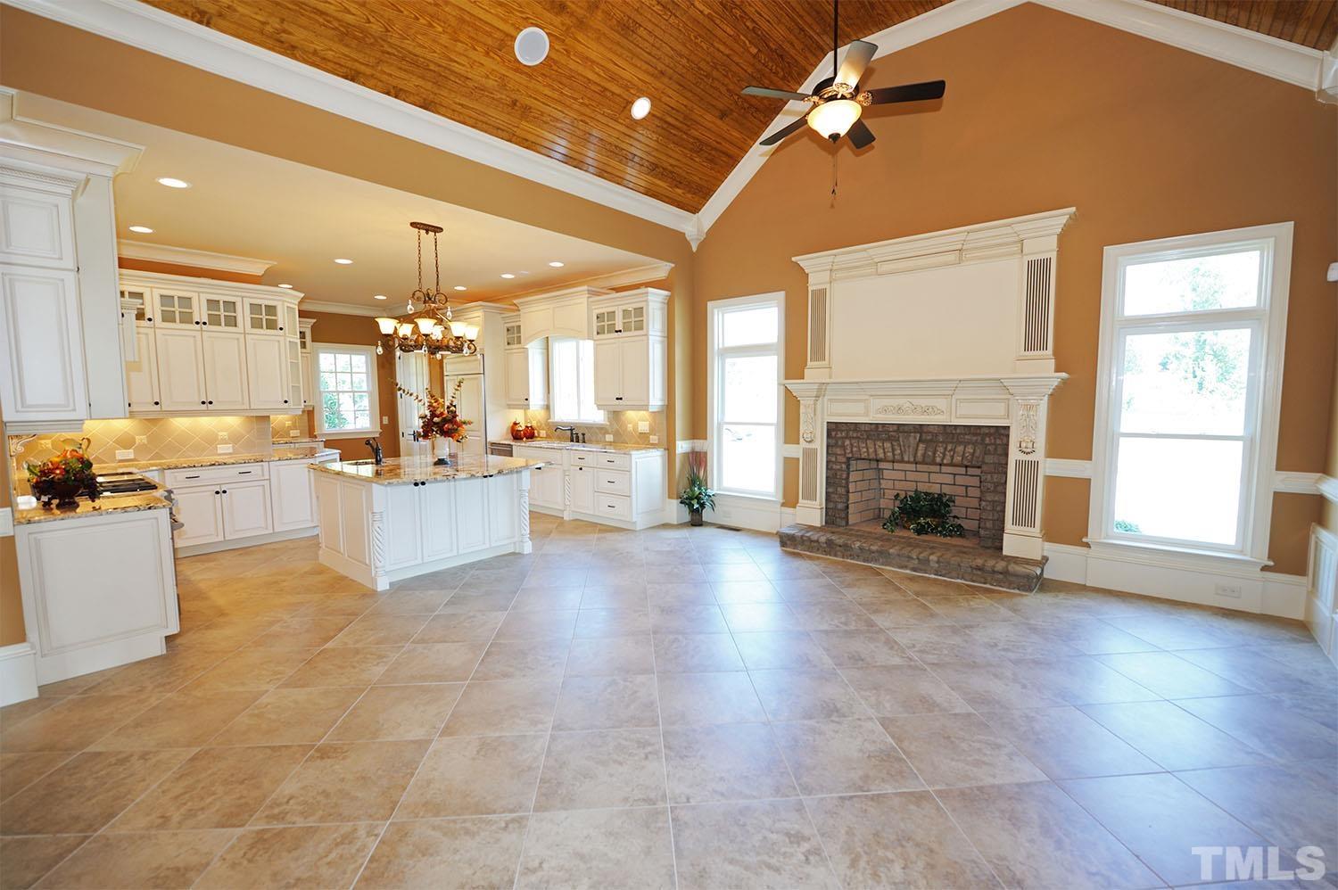 Cathedral ceiling with 1x6 stained bead board and oversized tile flooring. Masonry wood-burning fireplace that has a hand-painted and glazed mantle. Chair rail and crown moldings and 12