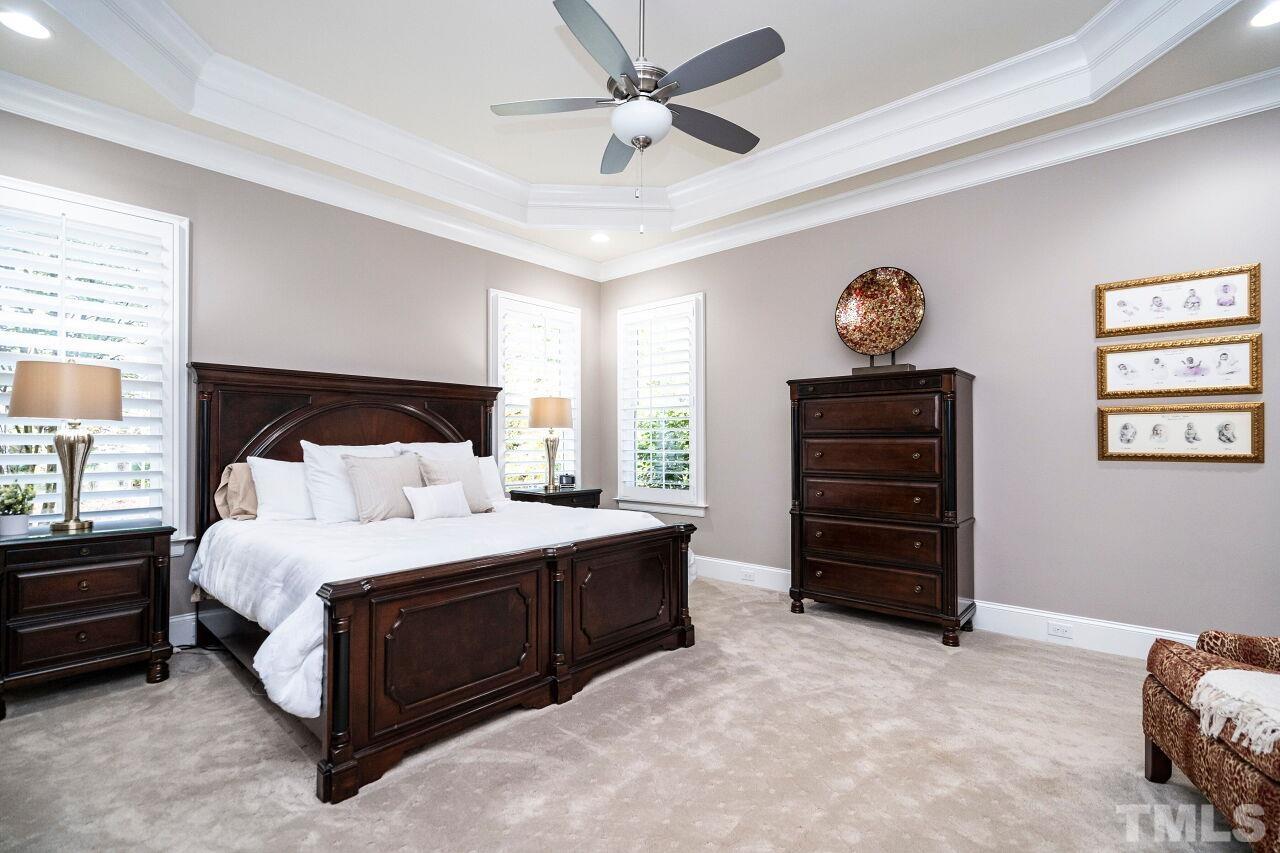 Owner's Suite with 10' tray ceilings, two piece crown, ceiling fan, plantation shutters and carpet floors.