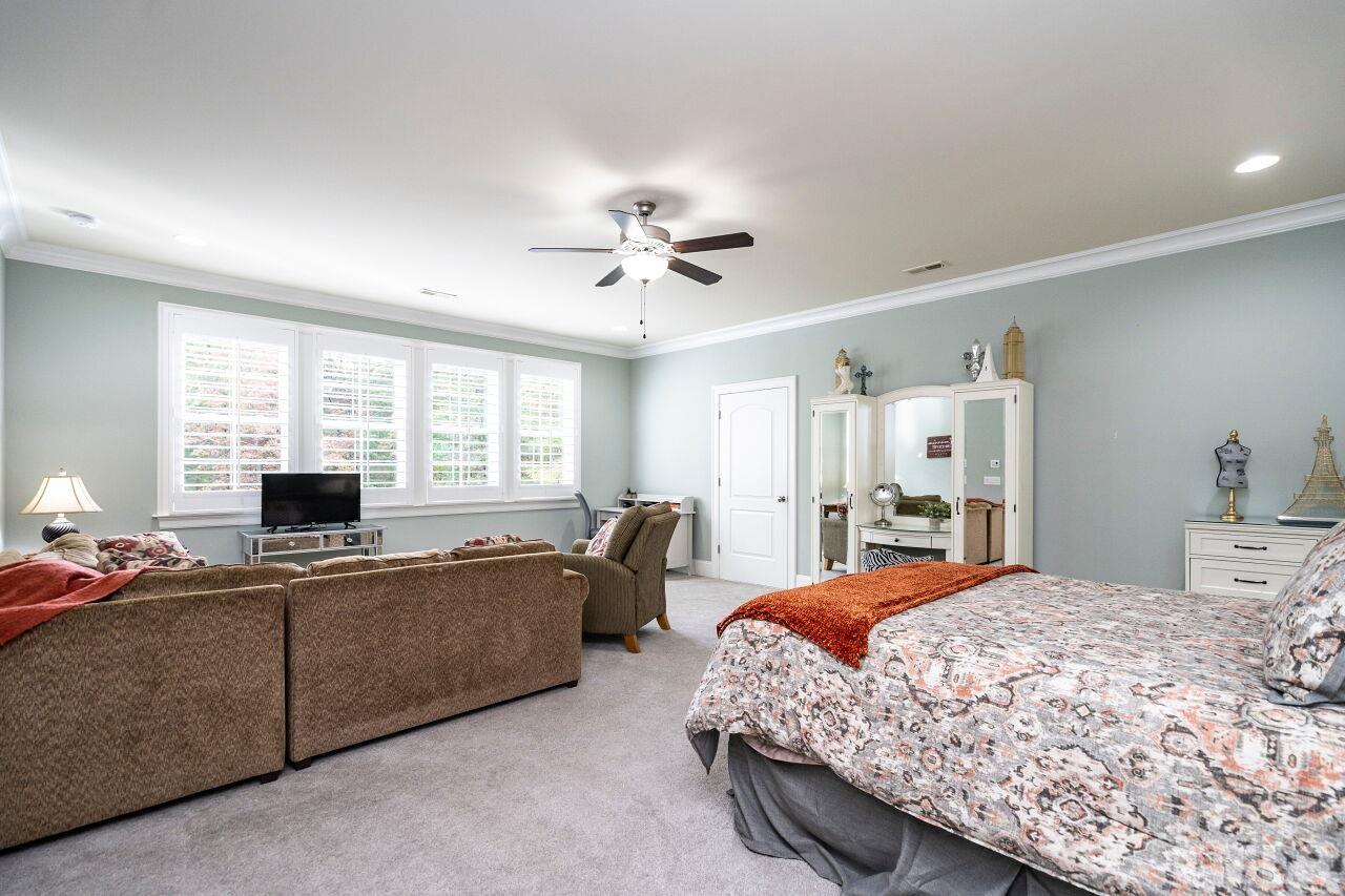 Guest Bedroom/Recreation Room: 9' Ceilings, Crown, Large Walk-In Closet, Ceiling Fan, access to finished storage area, plantation shutters and carpet floors.
