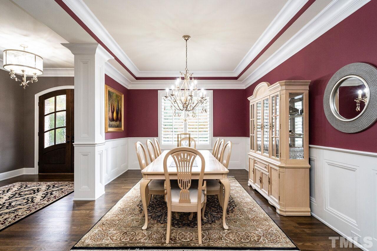 Dining Room with 10' tray ceiling, two piece crown, wainscot, columns, plantation shutters and hardwood floors.