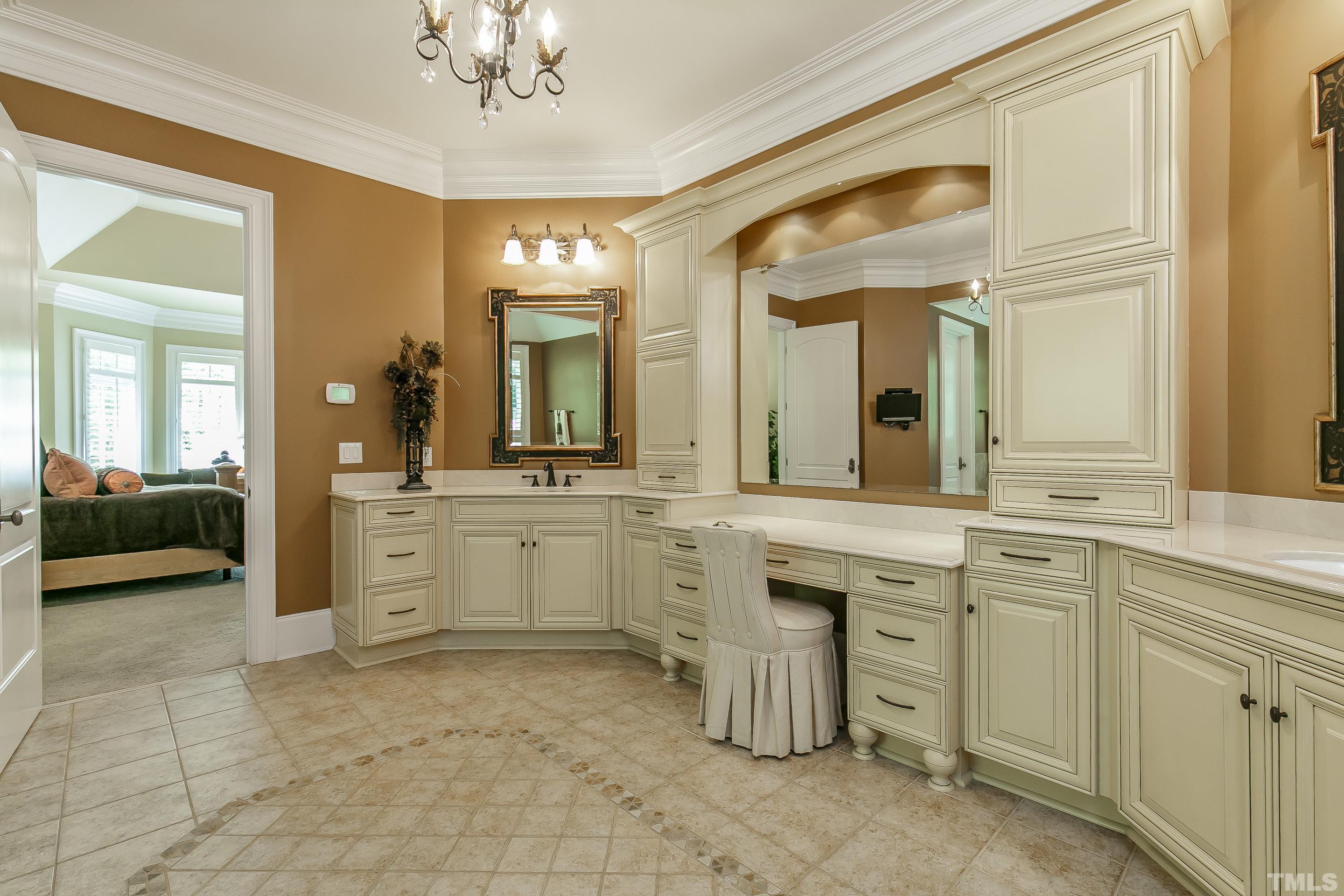 Relaxing oasis boasting 2 separate vanities, make up area, custom cabinets and tile floors