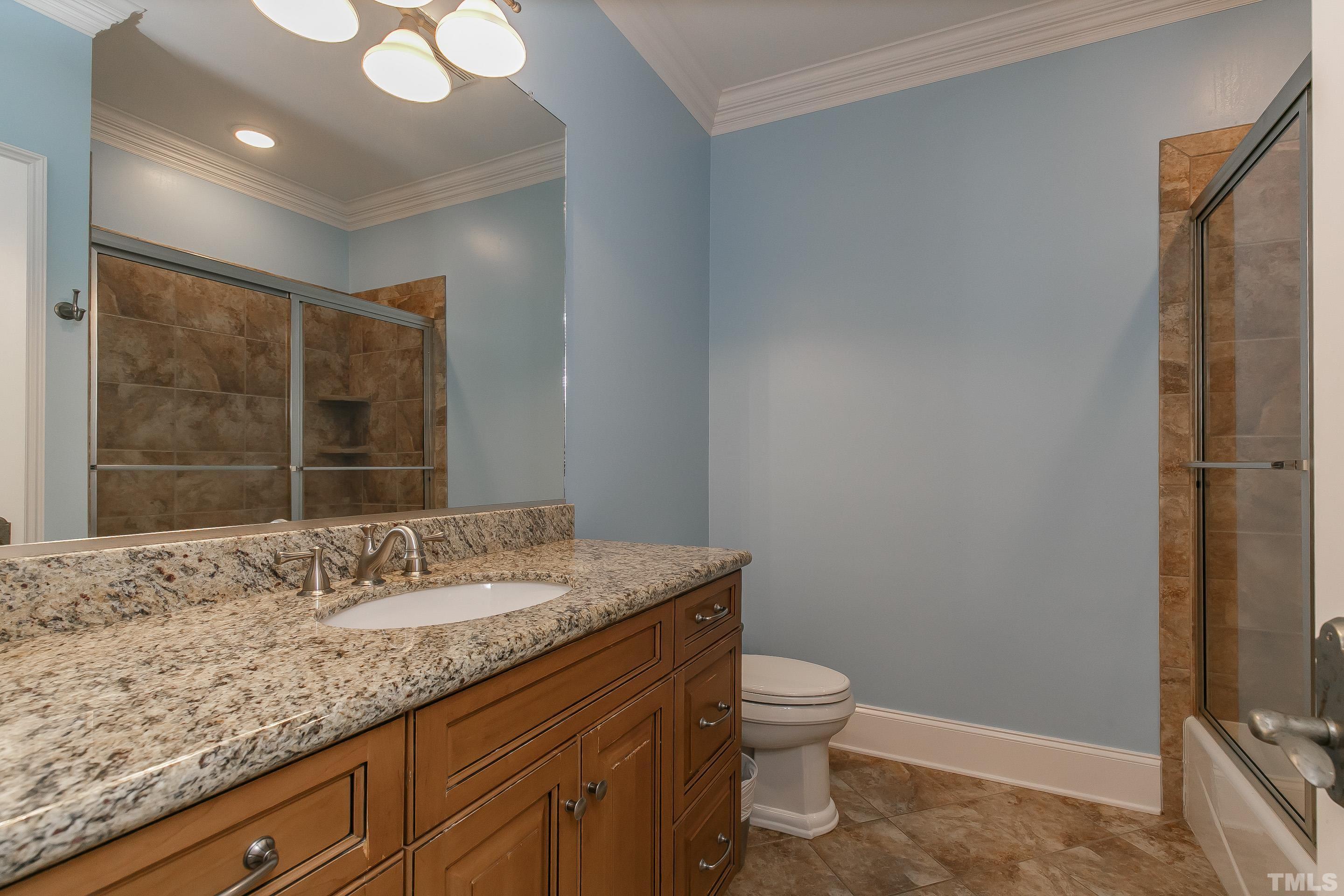 Extended granite vanity, tile flooring and tile surround shower/tub combo