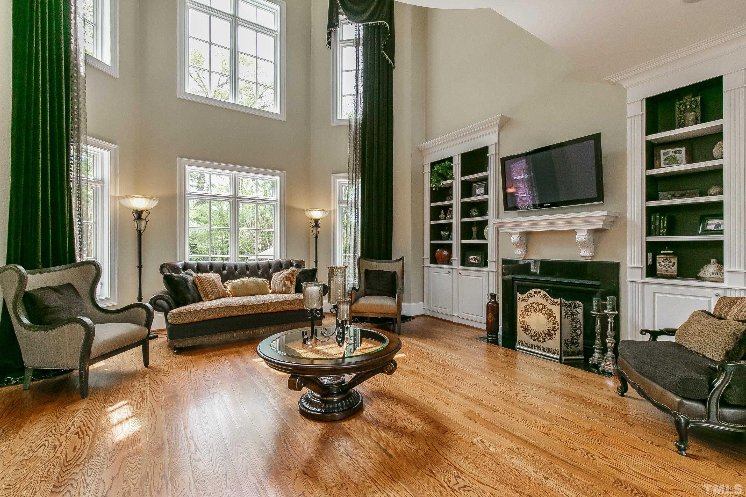 IMPRESSIVE 2 story living room with built-in bookcases/cabinets flanking gas log fireplace