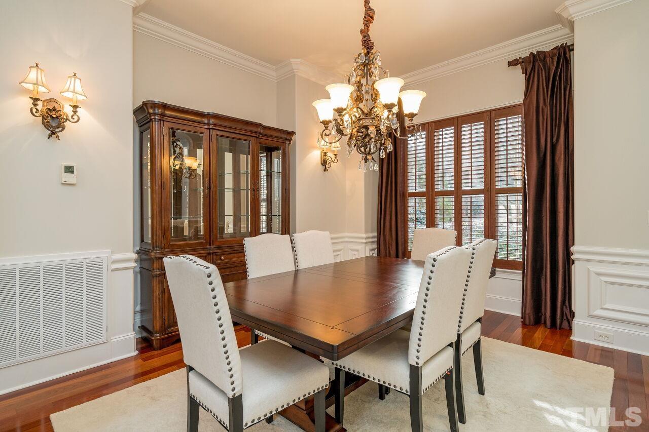 Wainscoting, custom window treatments, plantation shutters and a beautiful chandelier all combine to make this the ideal dining space.