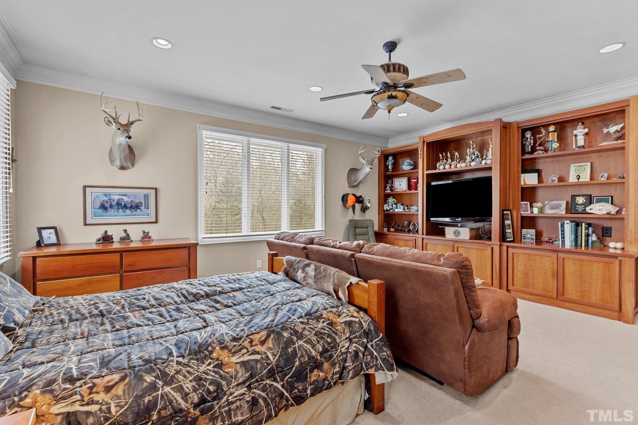 Large bedroom with custom built cabinetry, walk in closet and en suite bath
