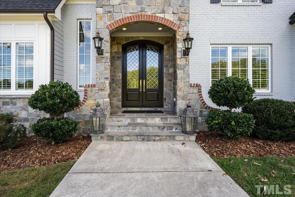 The entrance...well...makes an entrance. Circle drive, stone portico, gas lights, lake view, and double leaded glass doors welcome your guests.