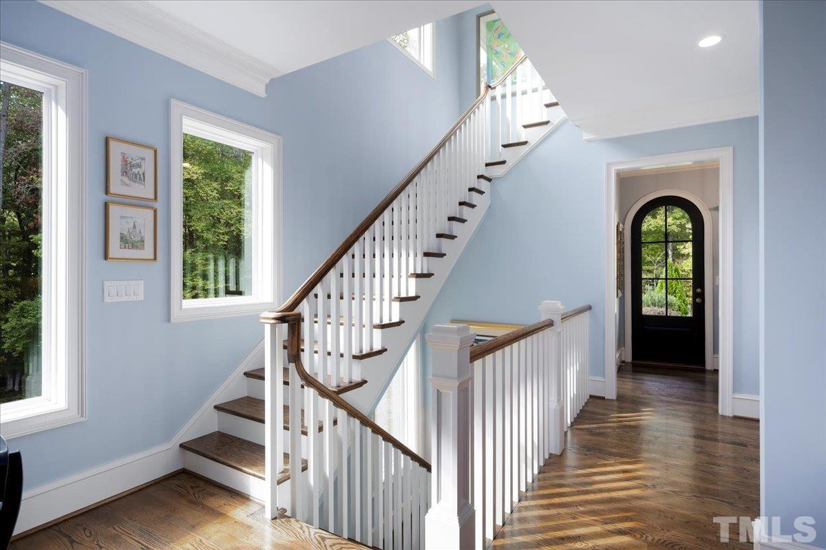 Rear staircase is as gorgeous as the main staircase. Stunning custom pendants grace the ceiling. Harwood treads to all three floors. Elevator shaft is opposite the staircase and spans all three floors.