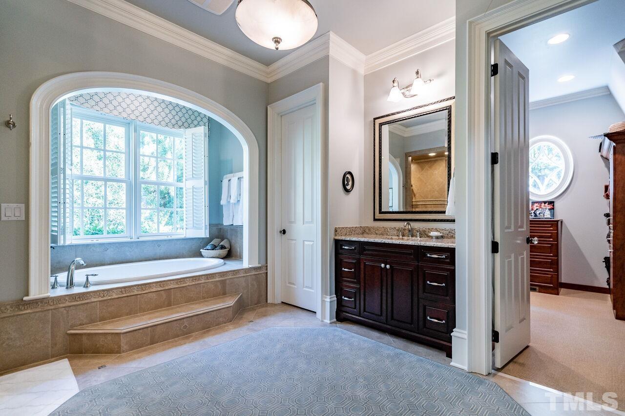 Step up to luxury with a roomy tub built into a gracefully arched alcove.