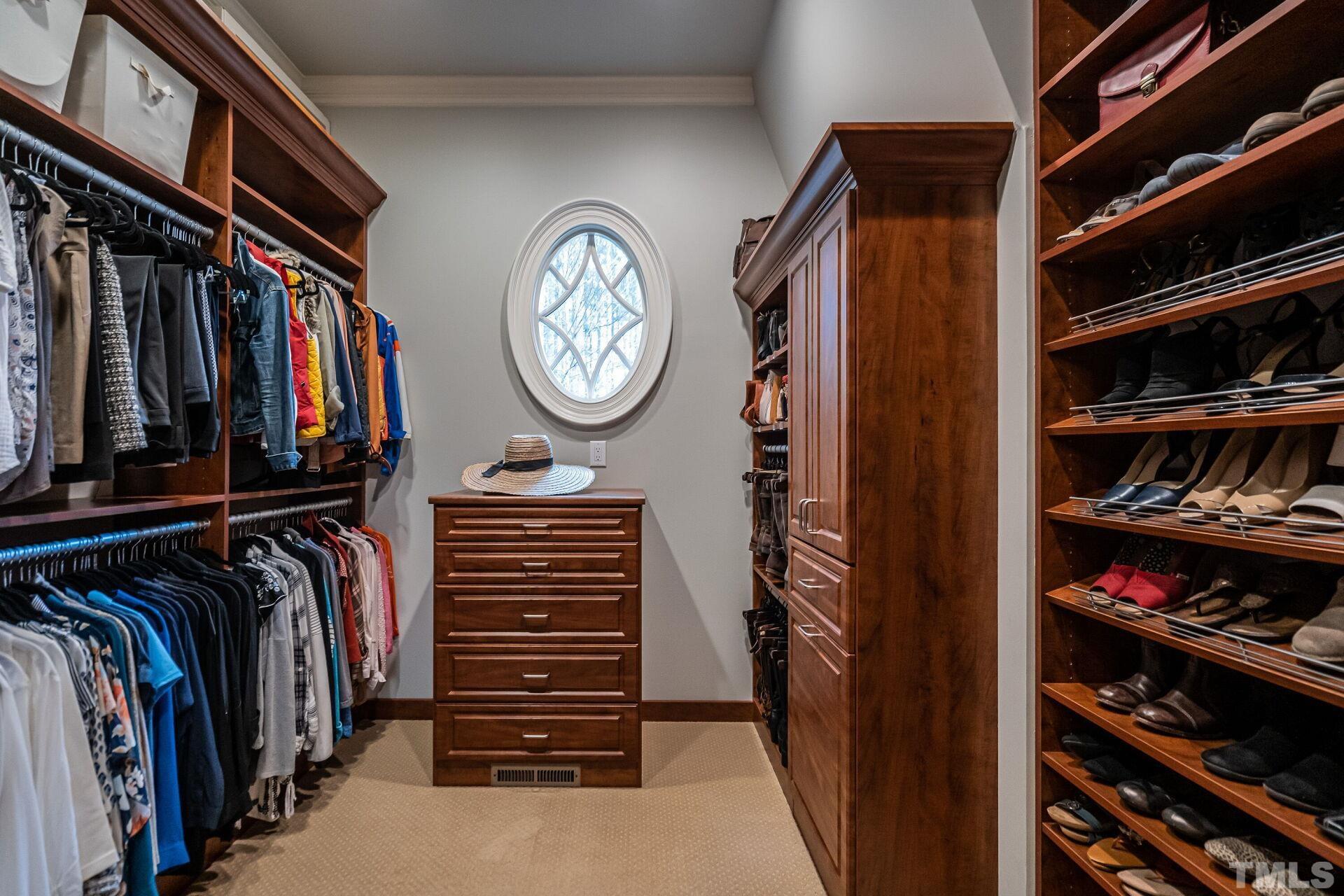 His and Hers custom cabinetry in separate closets.