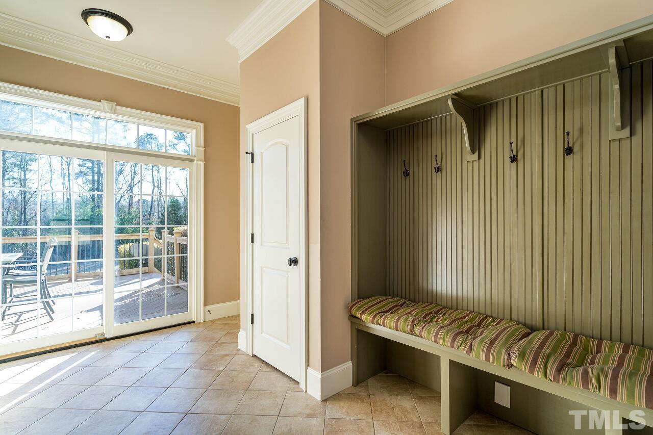 The mud room has custom seating and storage.  There's also access to the deck and garage.