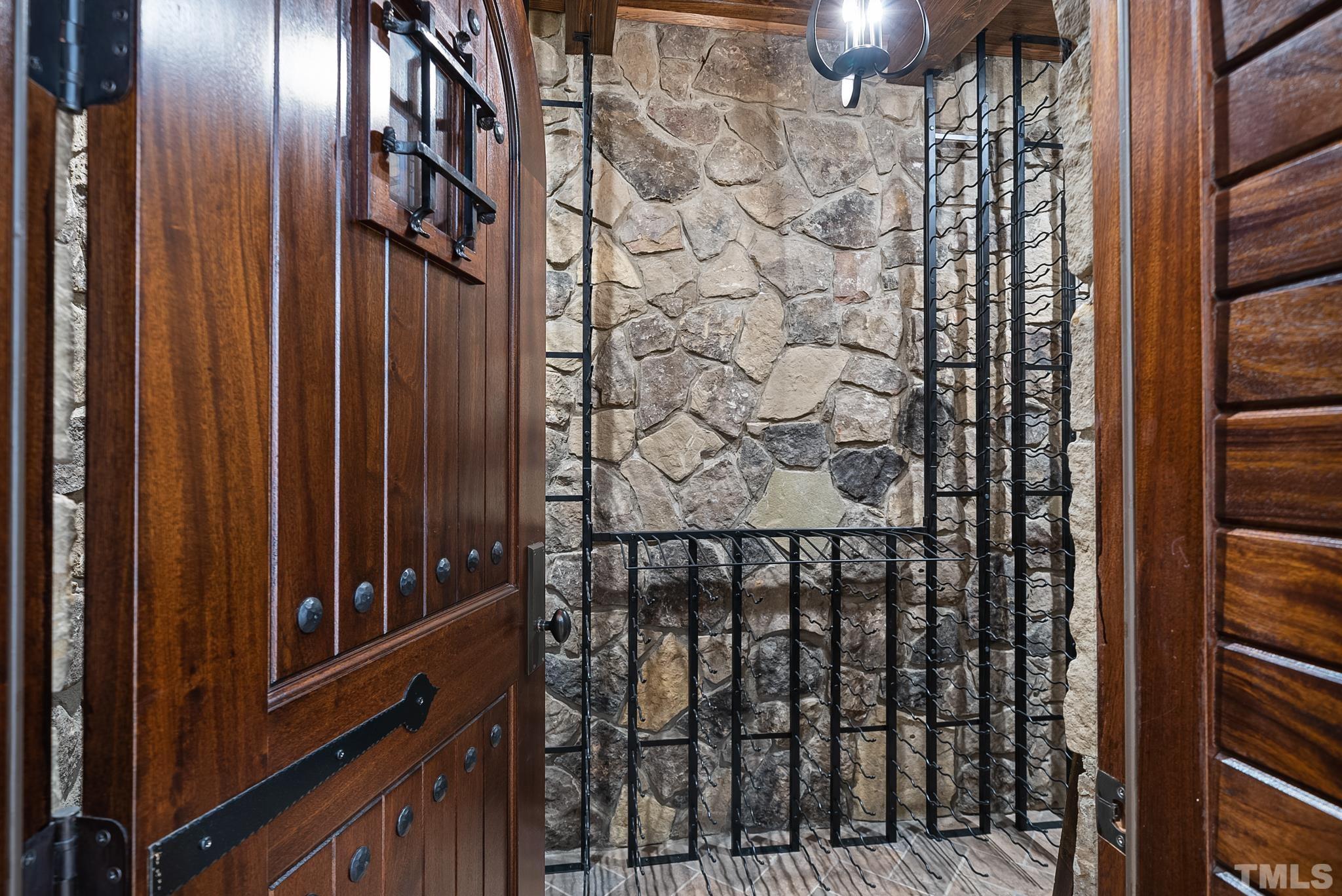 Stone wine cellar w/elegant solid custom door entry.