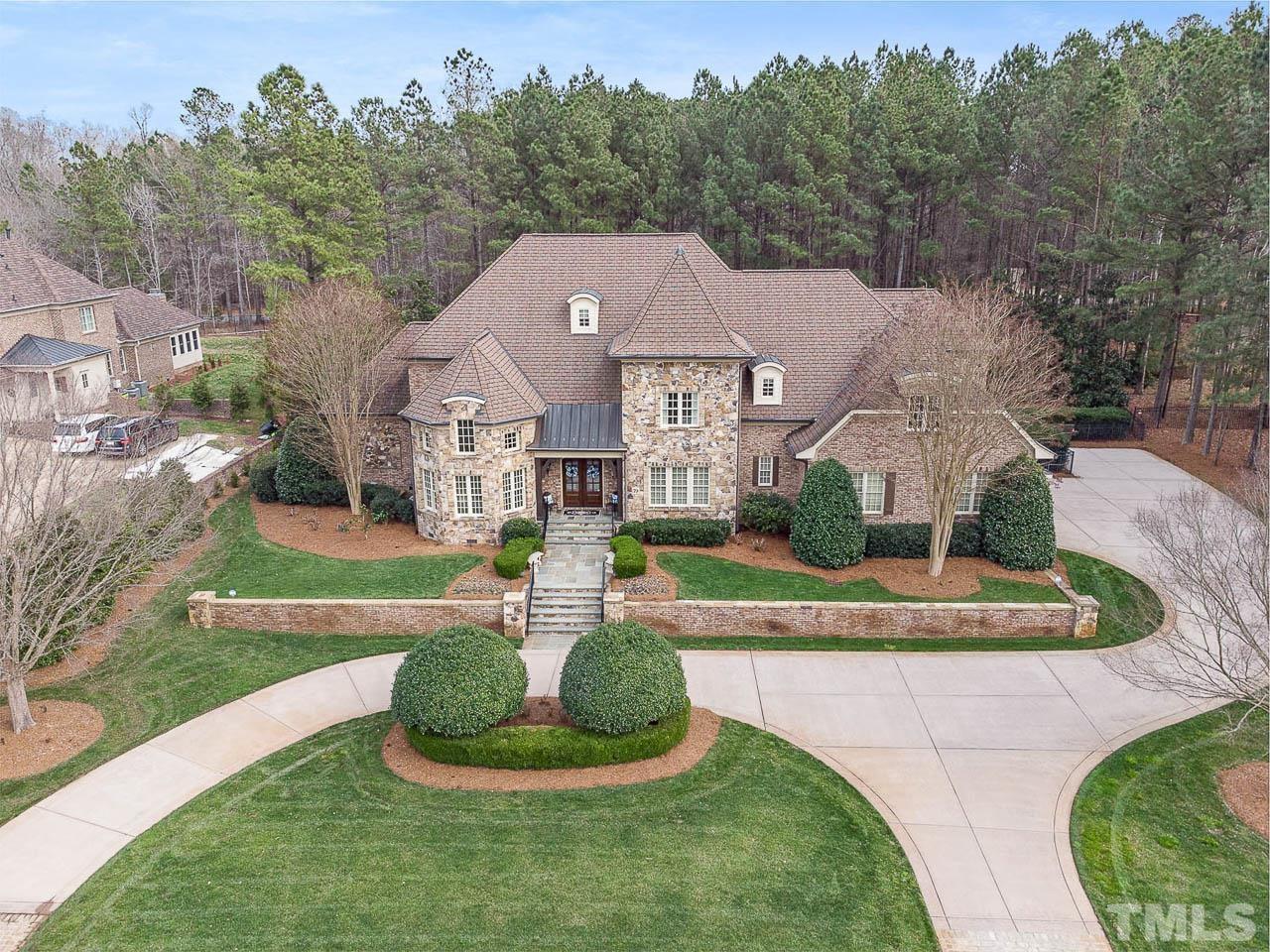 This lush landscaped property has a paved driveway with two entrances and a three car garage.