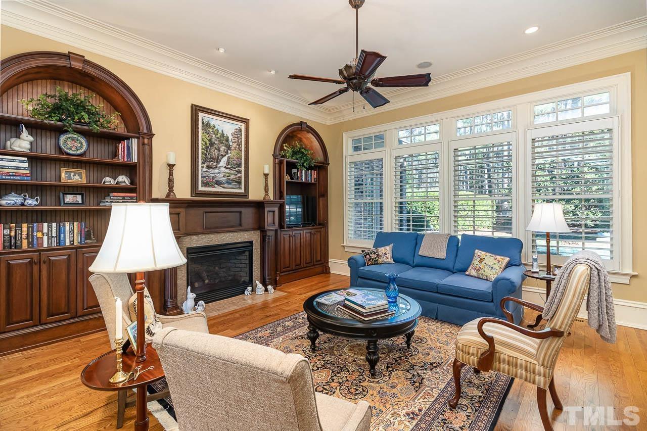 This living room is equipped with a fireplace and gorgeous cherry wood built in bookcases.