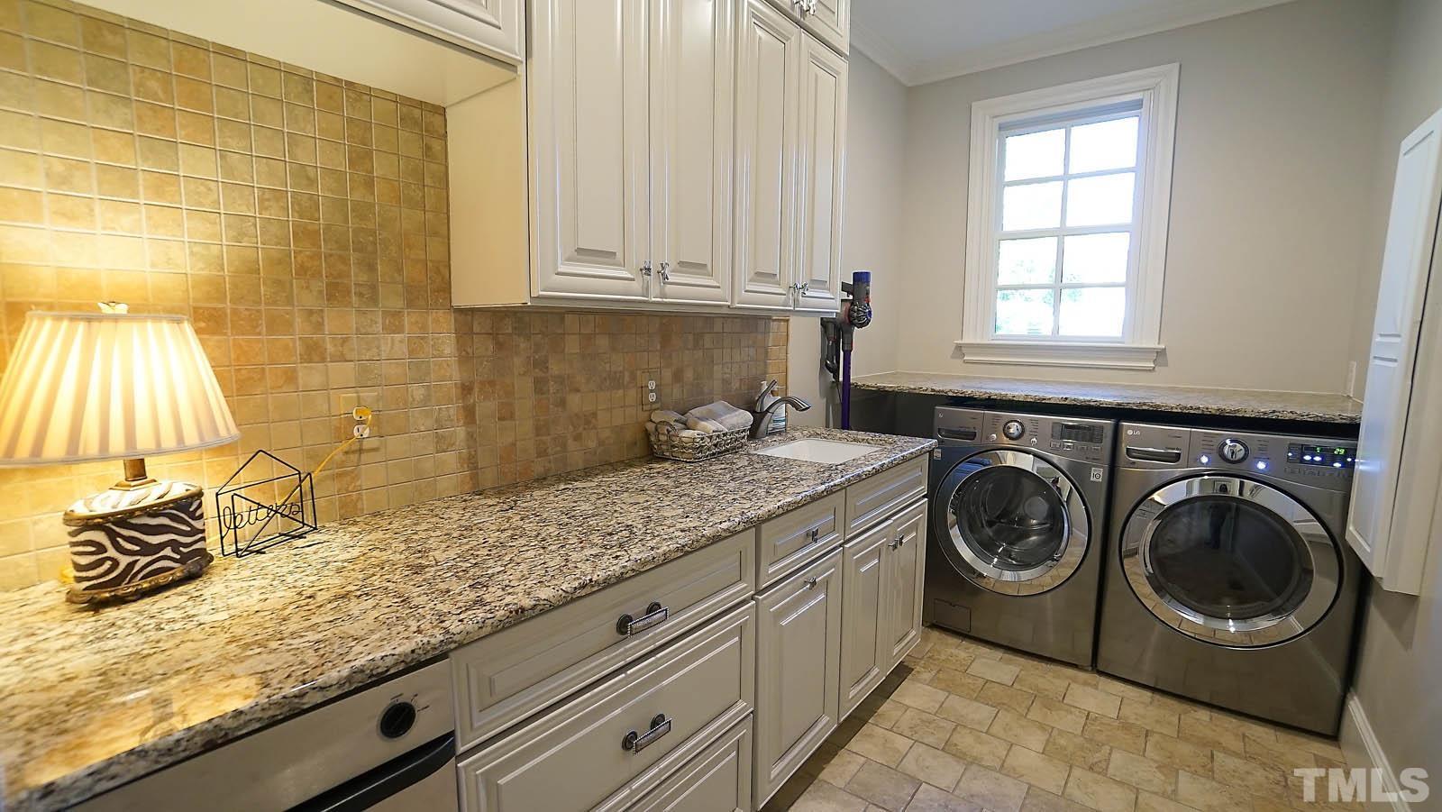 Laundry room with tons of cabinets, granite counters and tile flooring