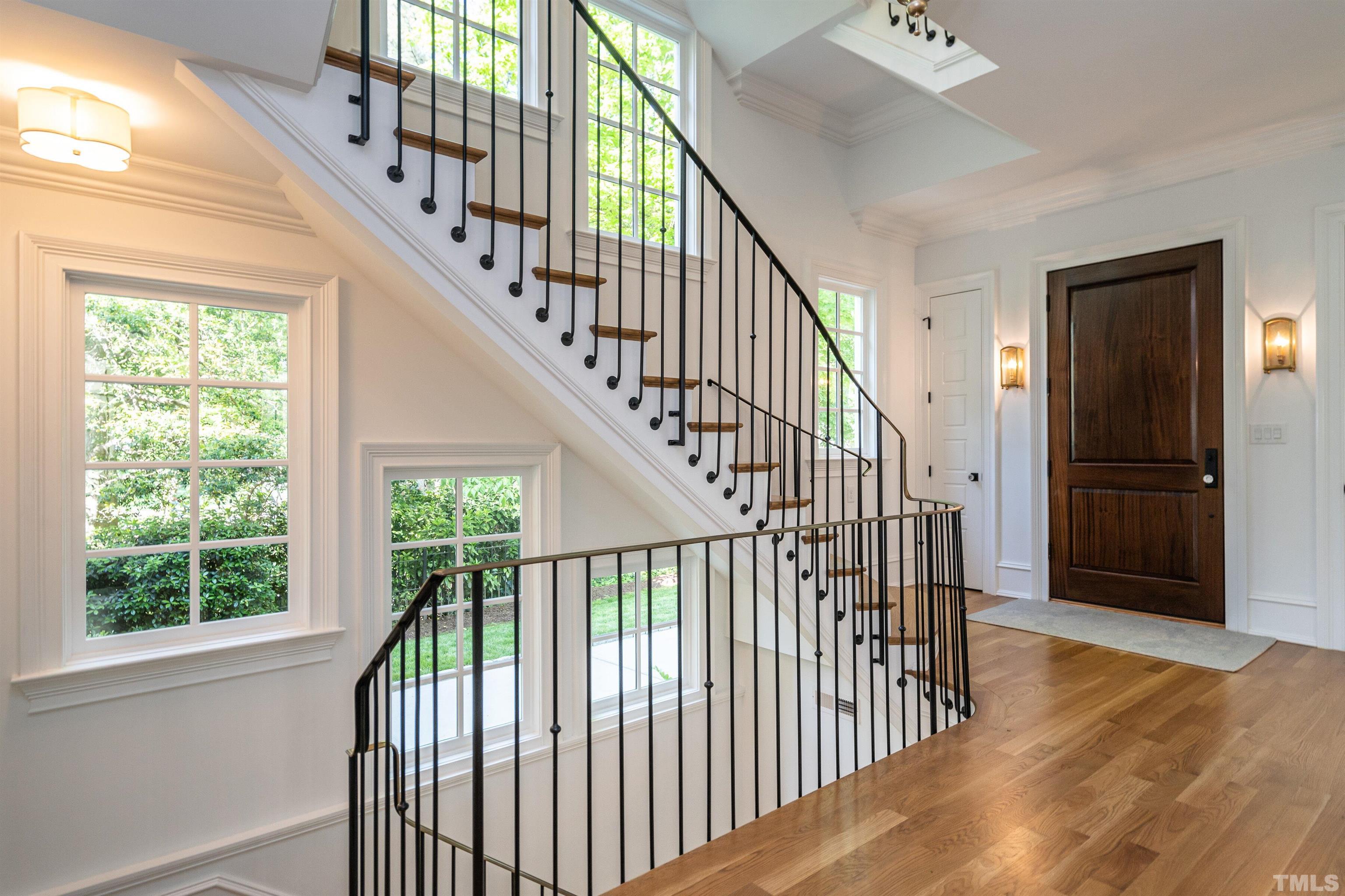 Refined yet sturdy, custom iron railing embellishes a graceful staircase.