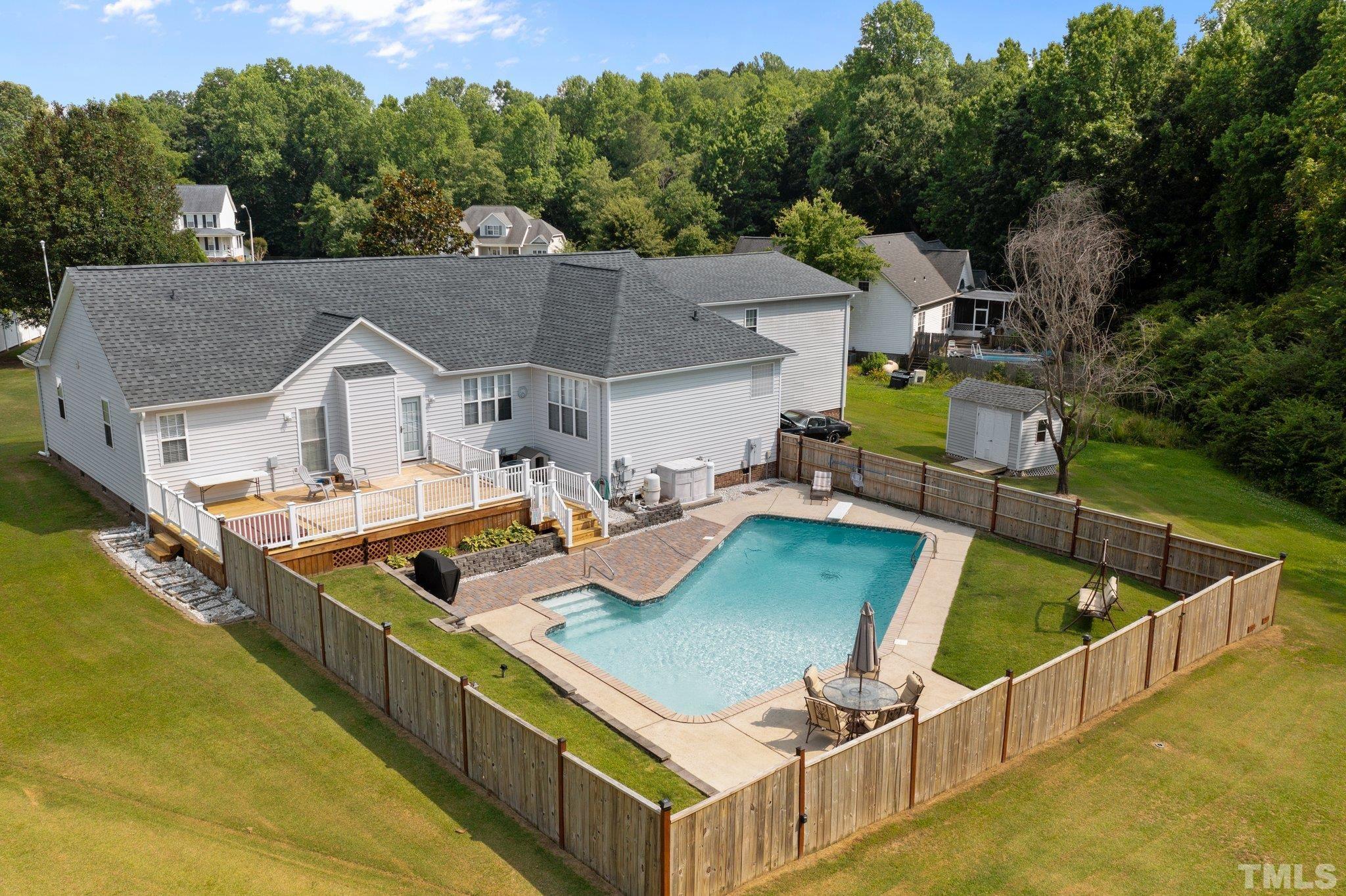 View of house, deck and fenced pool