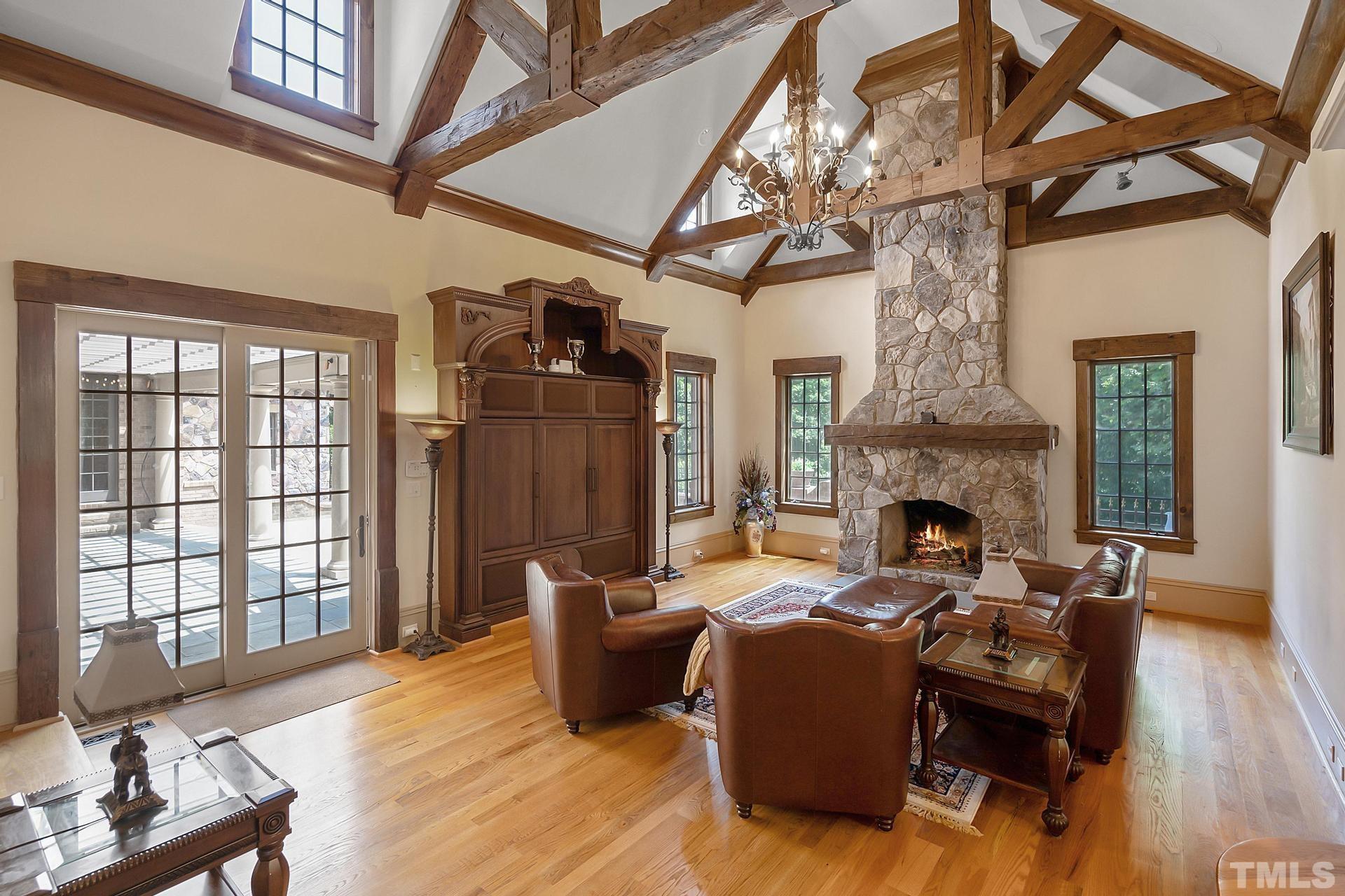 Exposed  wooden hammerbeam and the stone fireplace  exude comfort. Entry to the back patio and pool.
