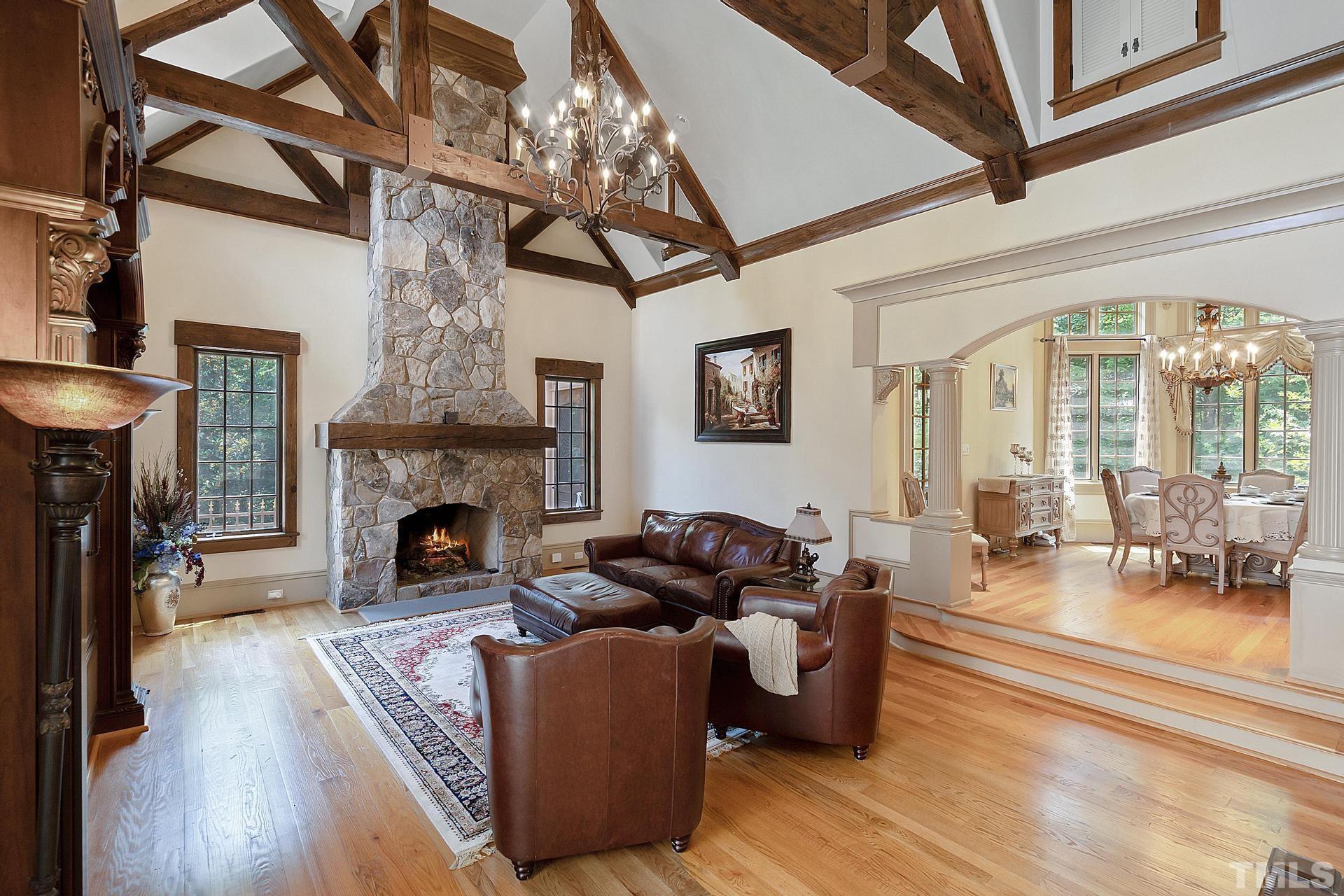 Exposed  wooden hammerbeam and the stone fireplace  exude comfort. Entry to the back patio and pool.