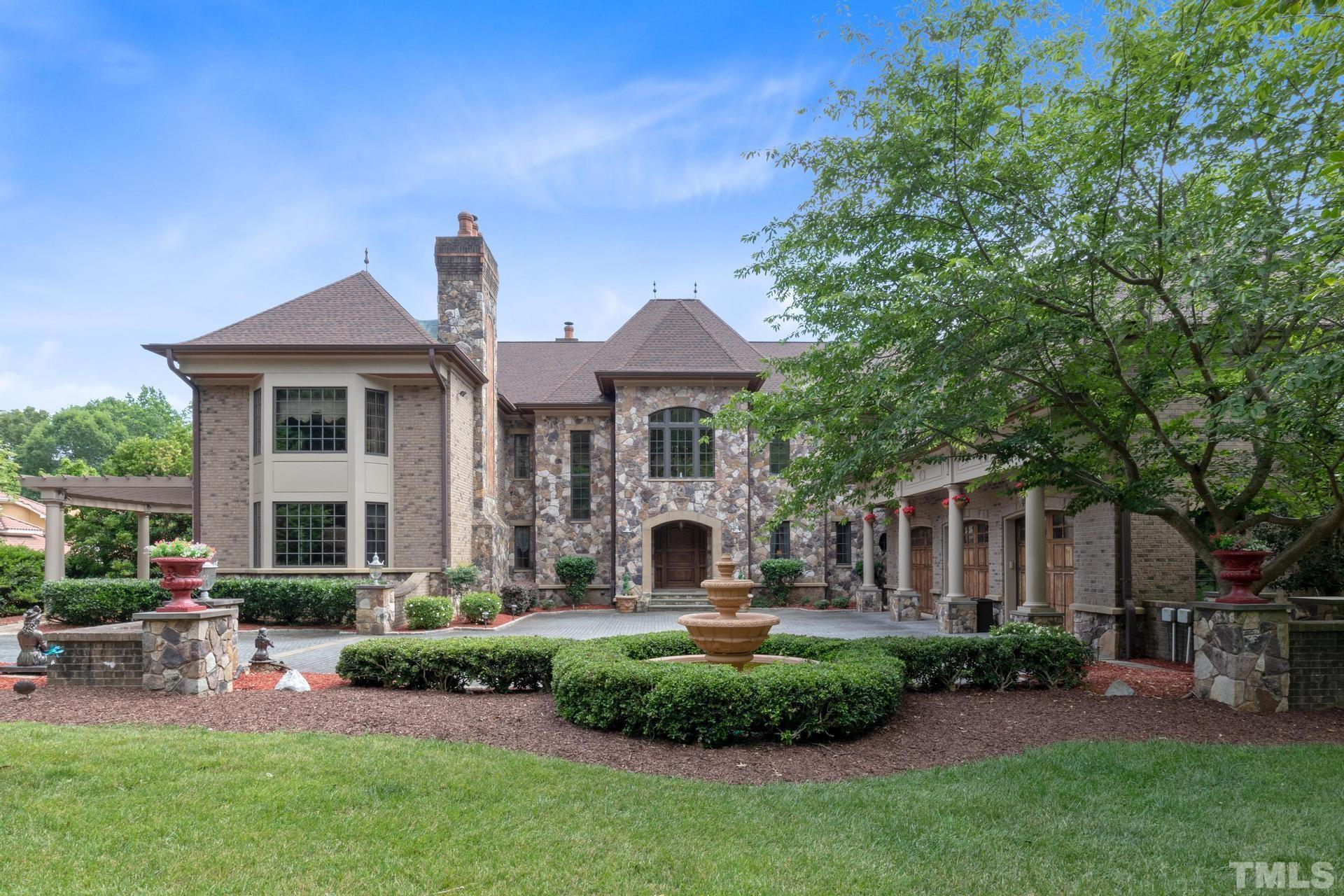 All brick or stone exterior, arched windows, hipped roof are classic French Provincial details. Lush landscaped front yard with a beautiful fountain.