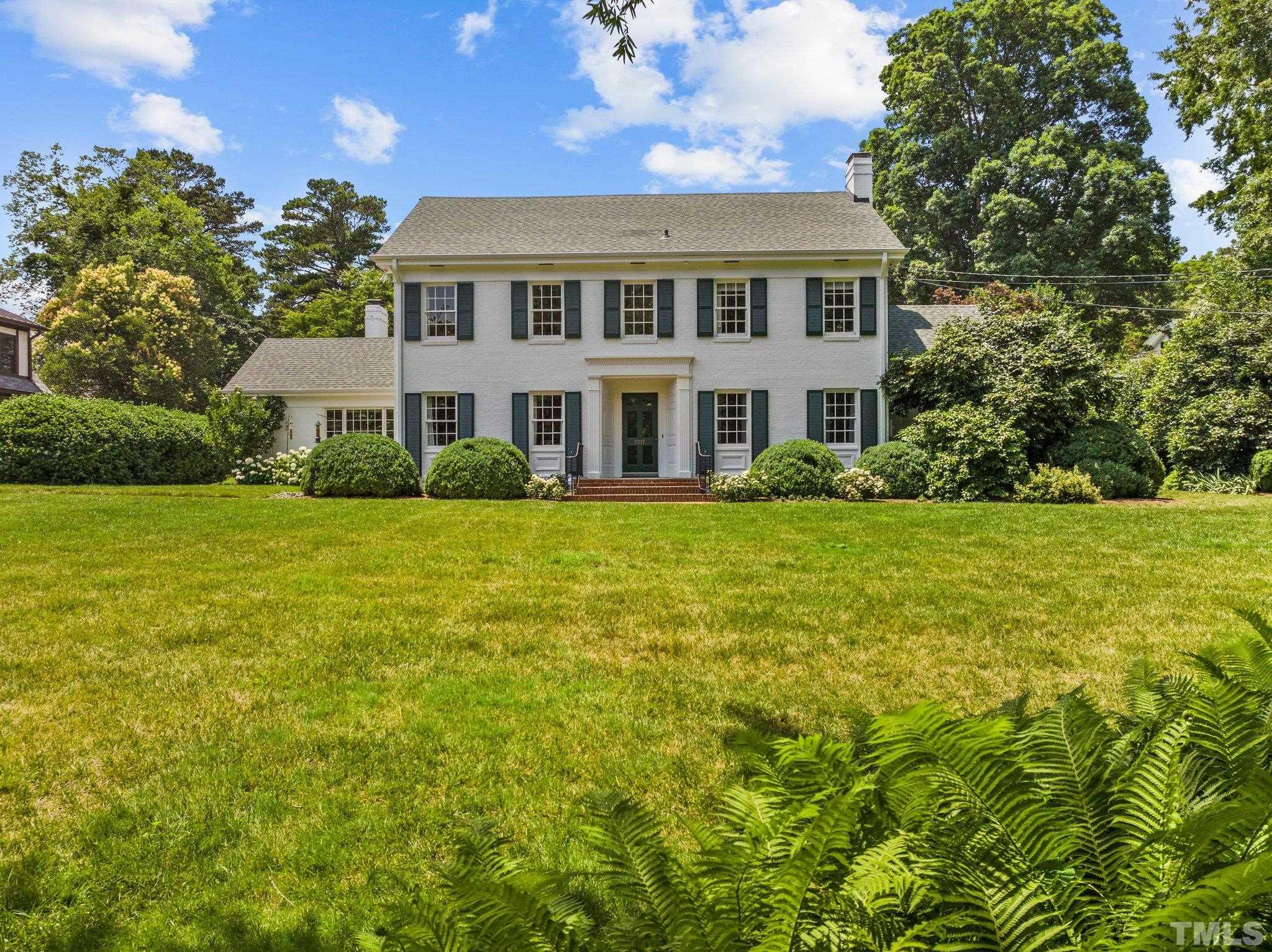 Exquisite classically designed brick home in Hayes Barton with enchanting gardens on 0.88 acres.